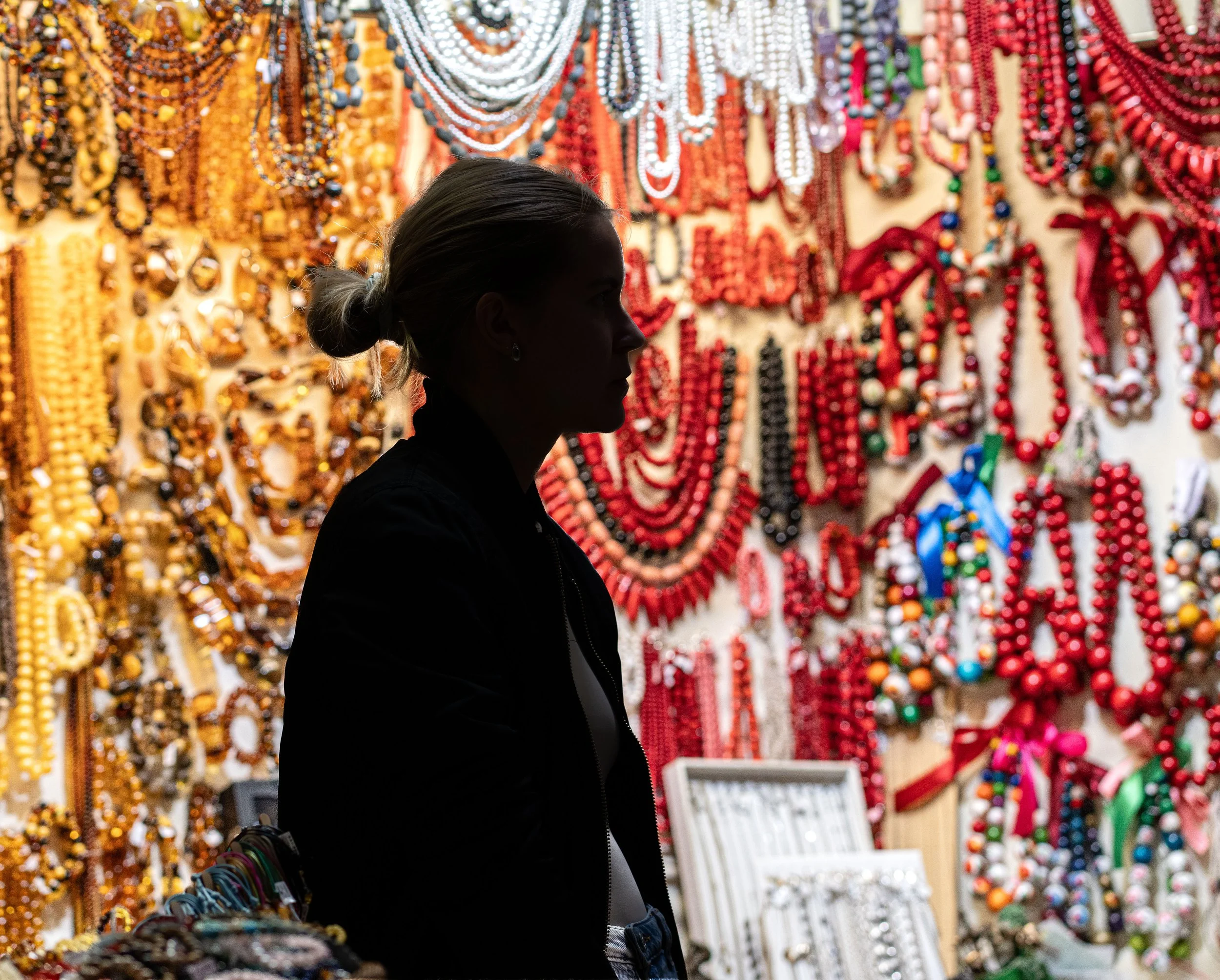 Krakow: A silhouette lingers among cascades of beads, where color turns silence into story.