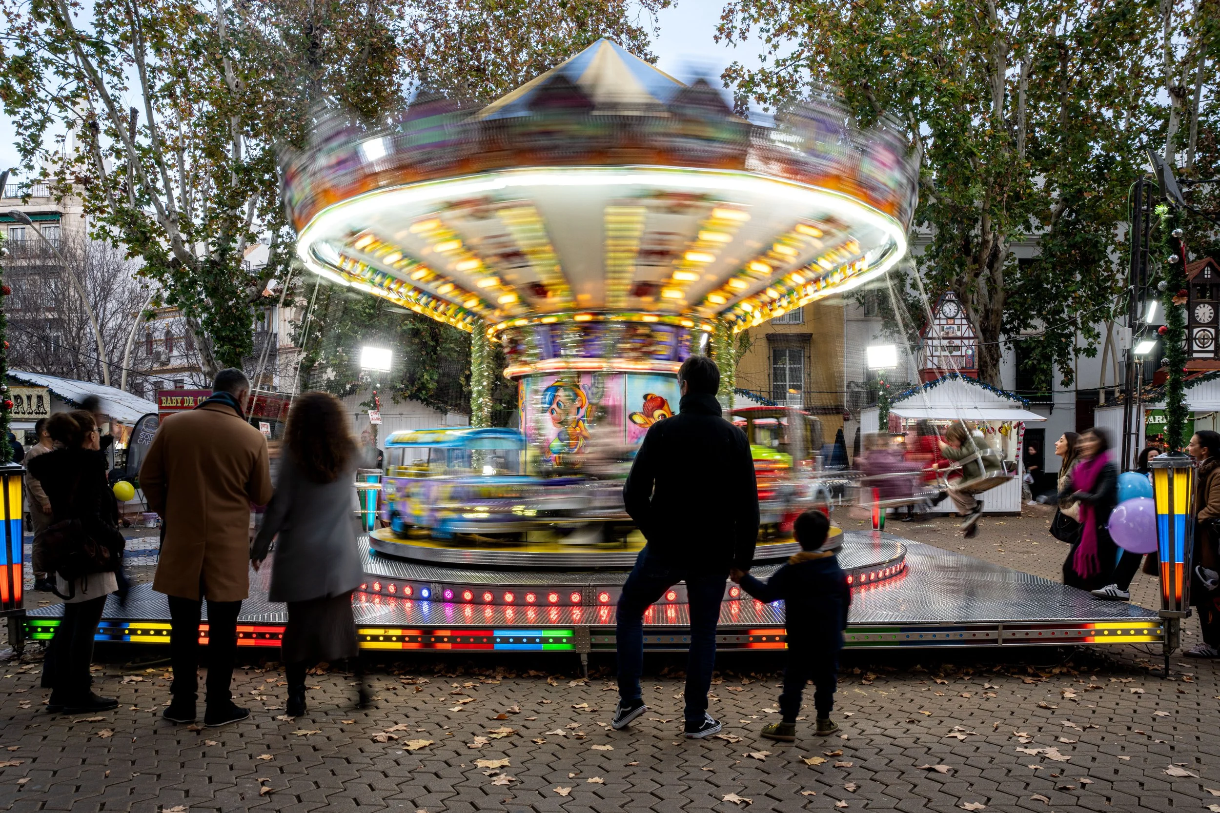 Sevilla - Lights spin, laughter swirls — childhood and memory dance together on a carousel of fleeting moments.