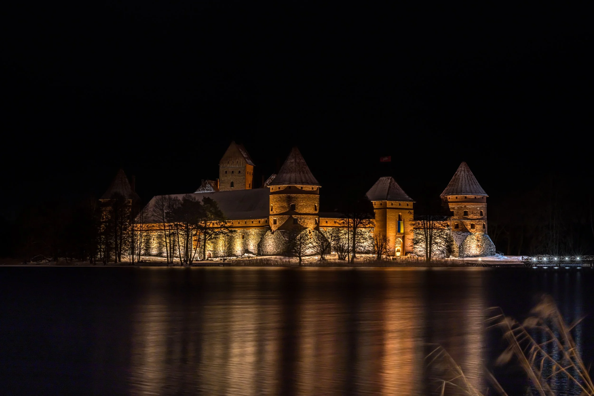 Trakai, Island Castle - Illuminated fortress over dark waters, echoing Lithuania’s medieval power, resilience, and silent majesty.