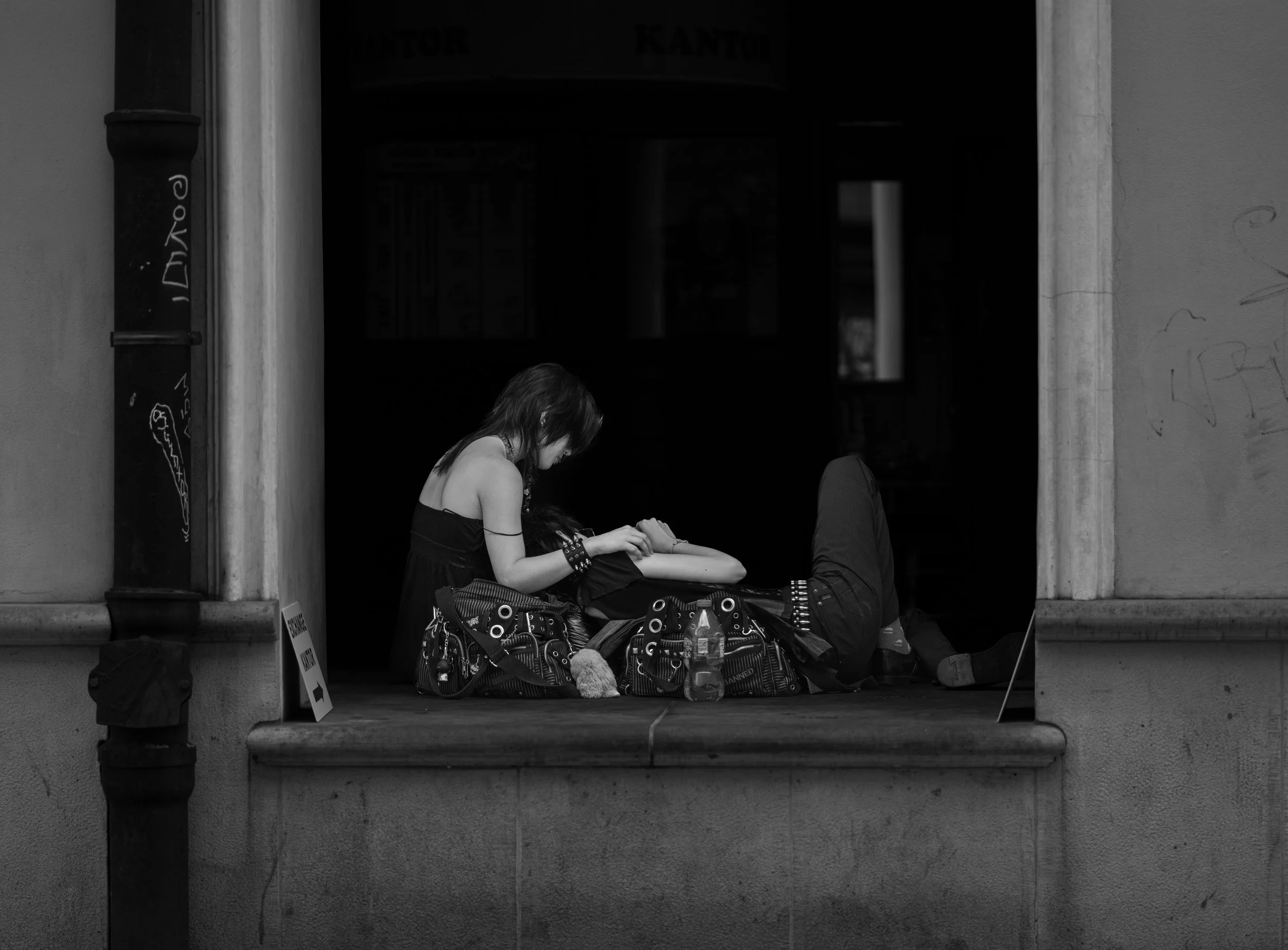 Krakow - In the city’s silence, two souls rest in shadows, love whispered gently against worn stone.