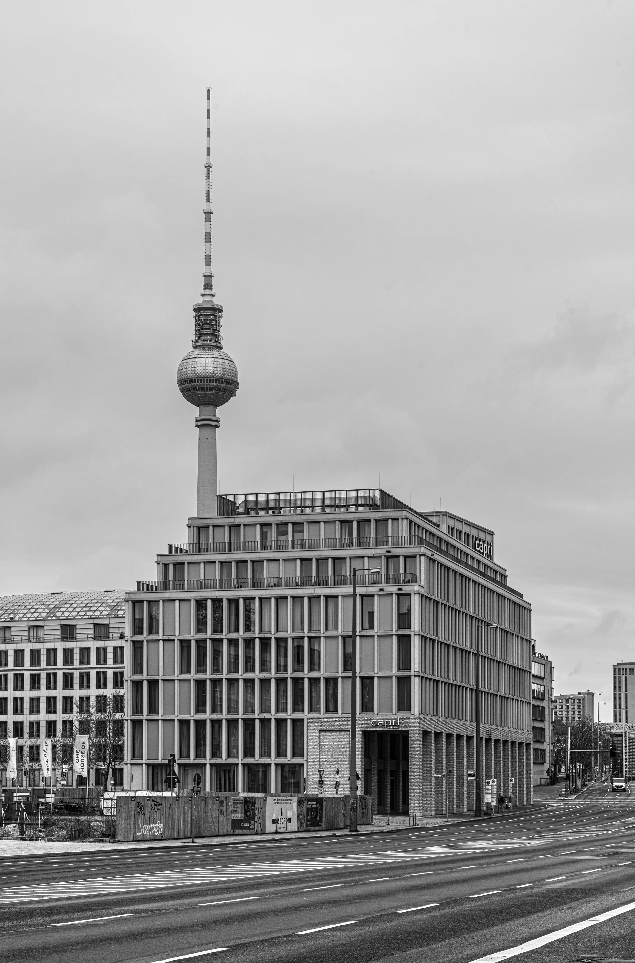 Berlin: The Fernsehturm cuts the sky above empty streets, where silence writes its own geometry.