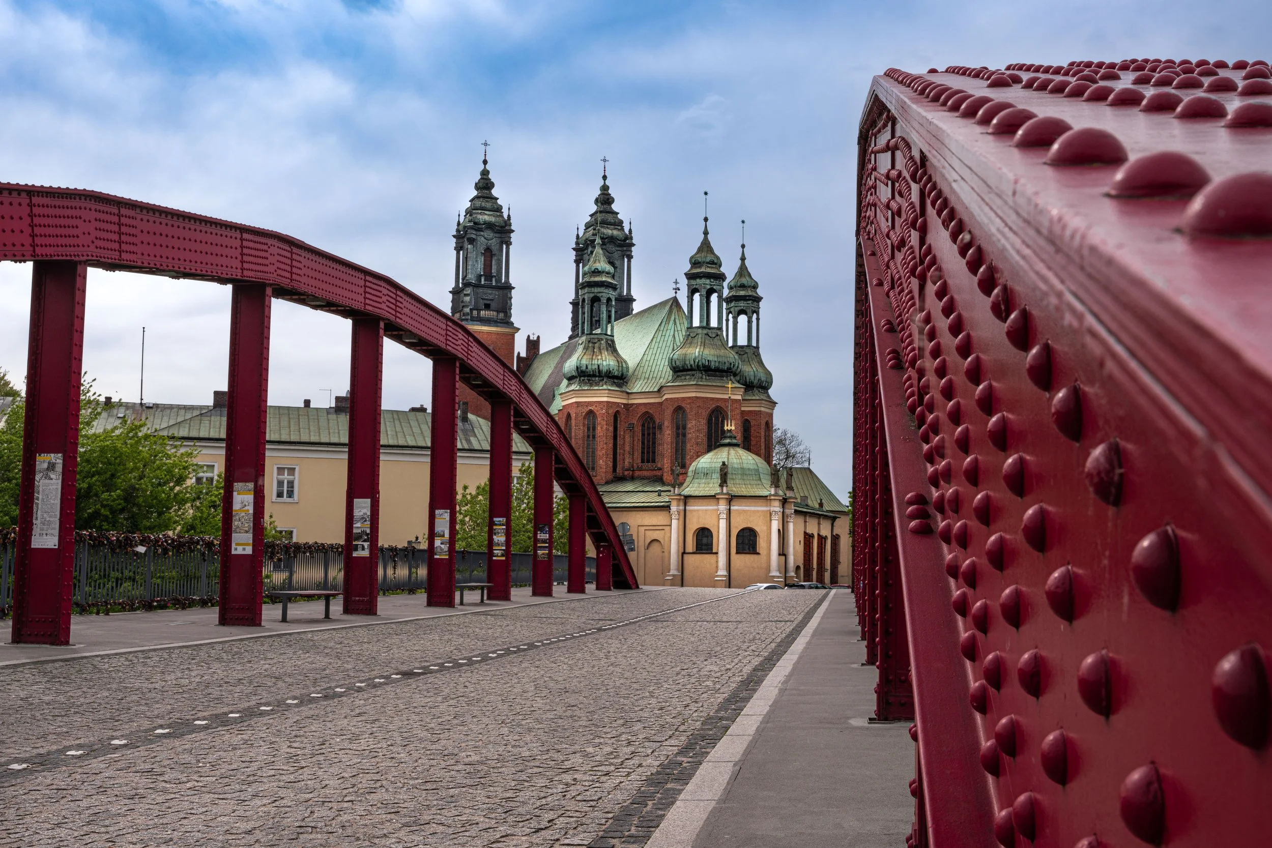 Poznań: A red bridge leads the eye to sacred towers, where history and faith cross paths.