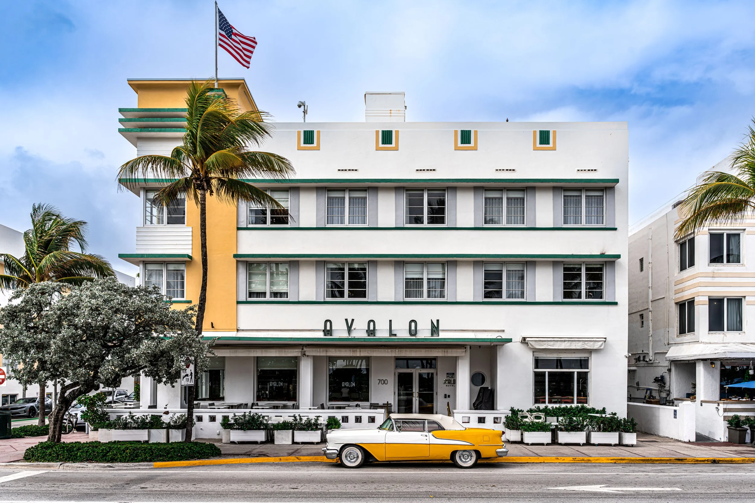 Miami: Art Deco facades and a yellow classic car, where the city pauses between ocean breeze and timeless charm.