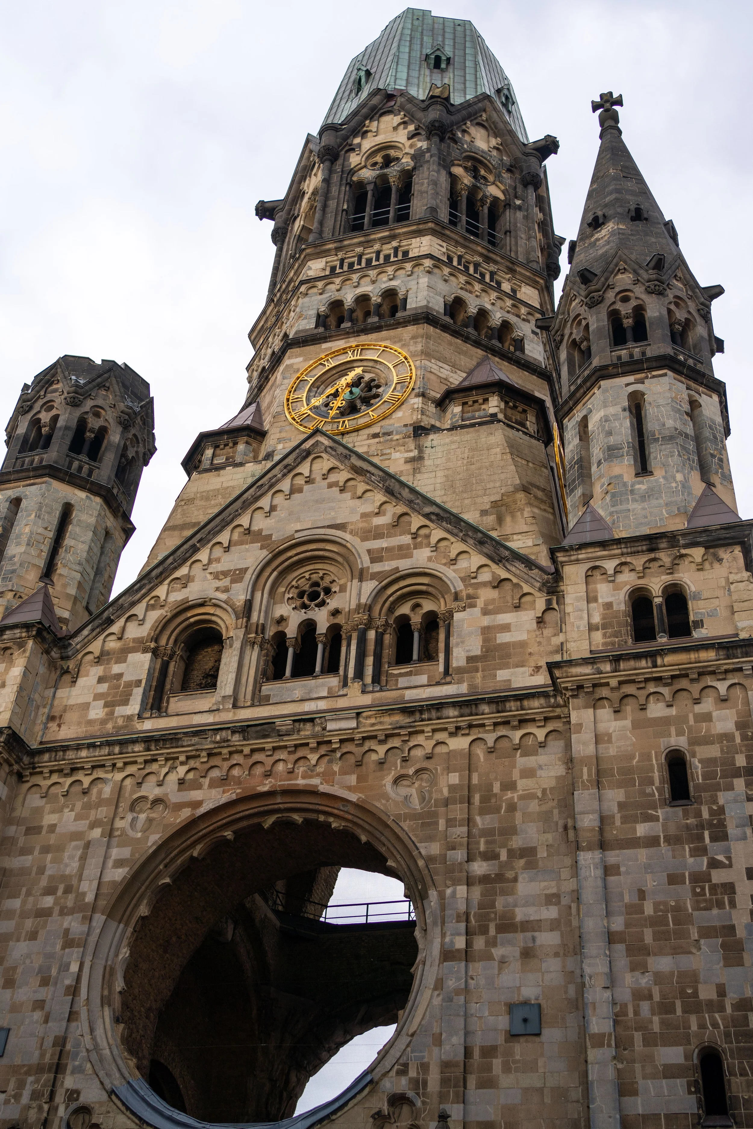 Berlin, Kaiser Wilhelm Memorial Church - Ruined spire stands as silent witness, war’s scars preserved in sacred stone.
