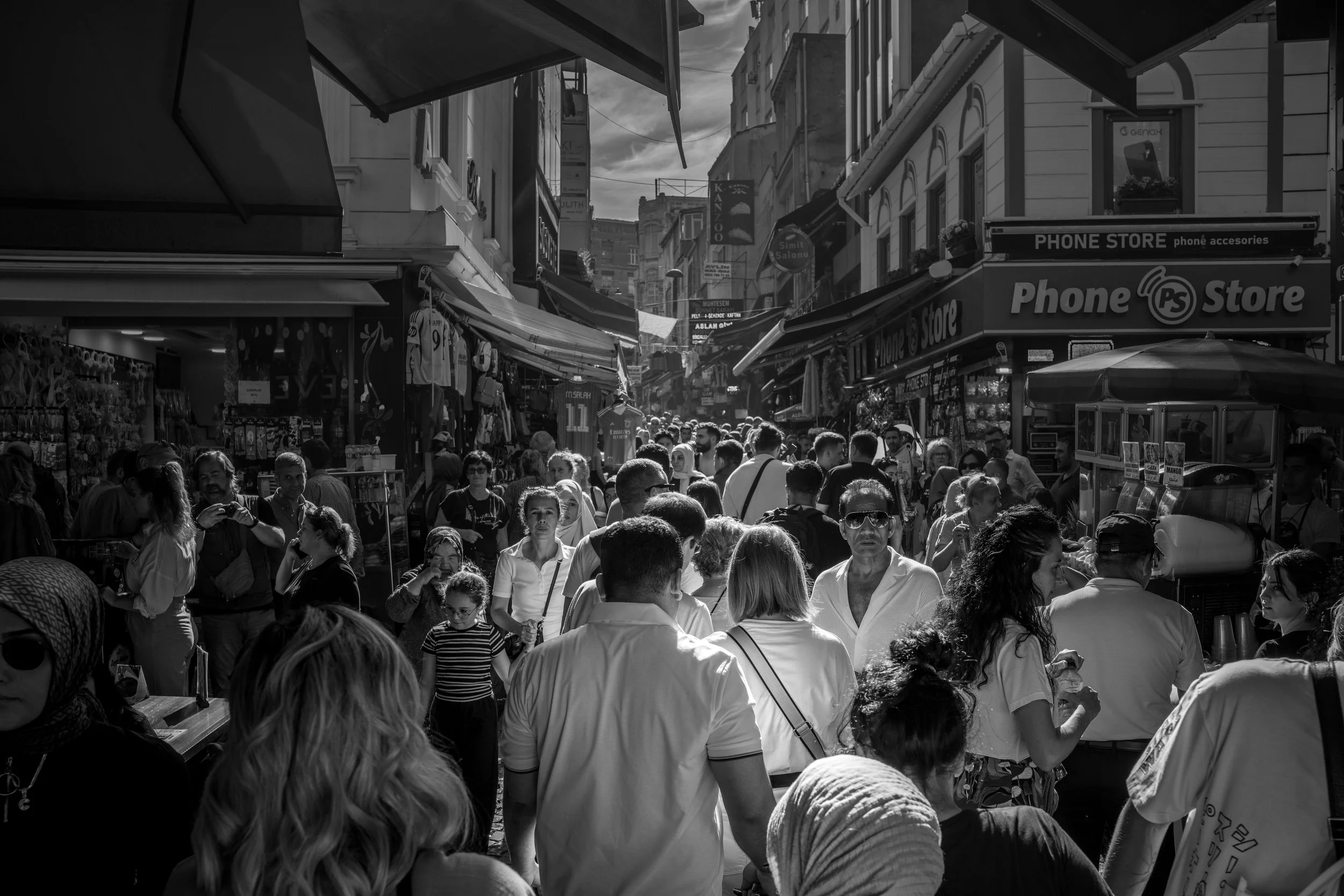 Istanbul - Crowded alleys breathe with sunlight, shadows weaving stories between strangers, where every glance holds eternity.