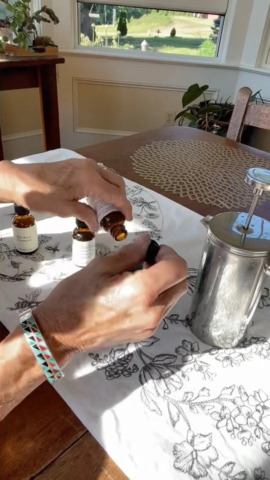 Hands pouring tincture into mug