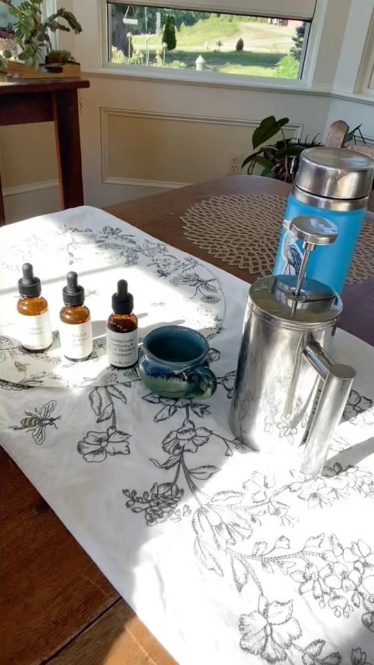 Row of tincture bottles and mug on sunny kitchen table