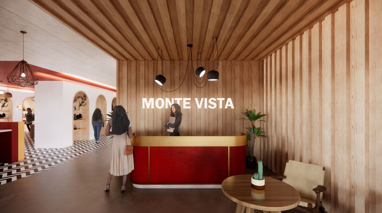 Lobby reception area with a wooden interior at Monte Vista, featuring a curved red and gold reception desk, black pendant lights, and a woman standing at the counter. There is a small table with a cactus plant, a beige chair, and a wooden wall panel.