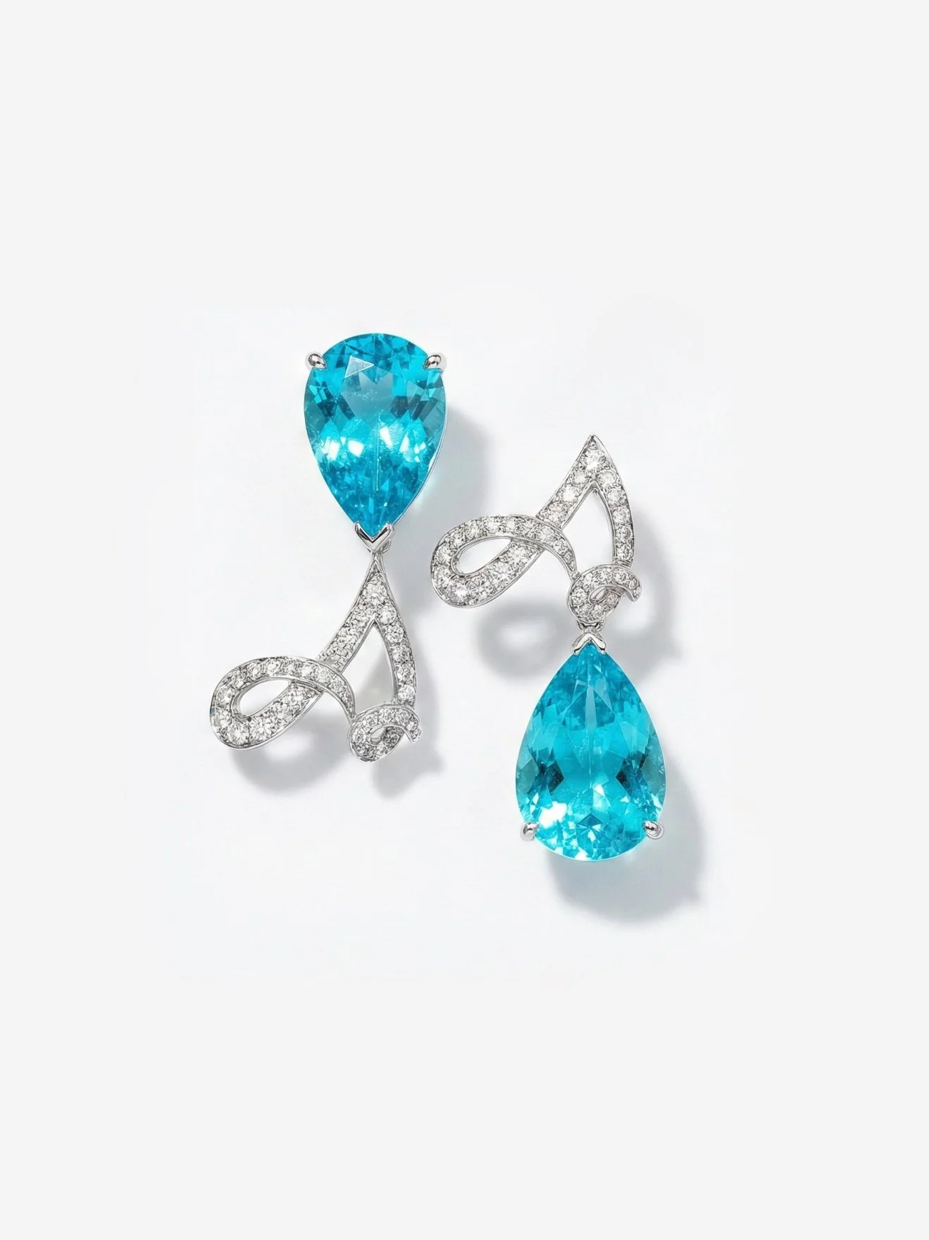 A pair of earrings with large teardrop-shaped blue gemstones surrounded by small diamonds and intricate silver setting.