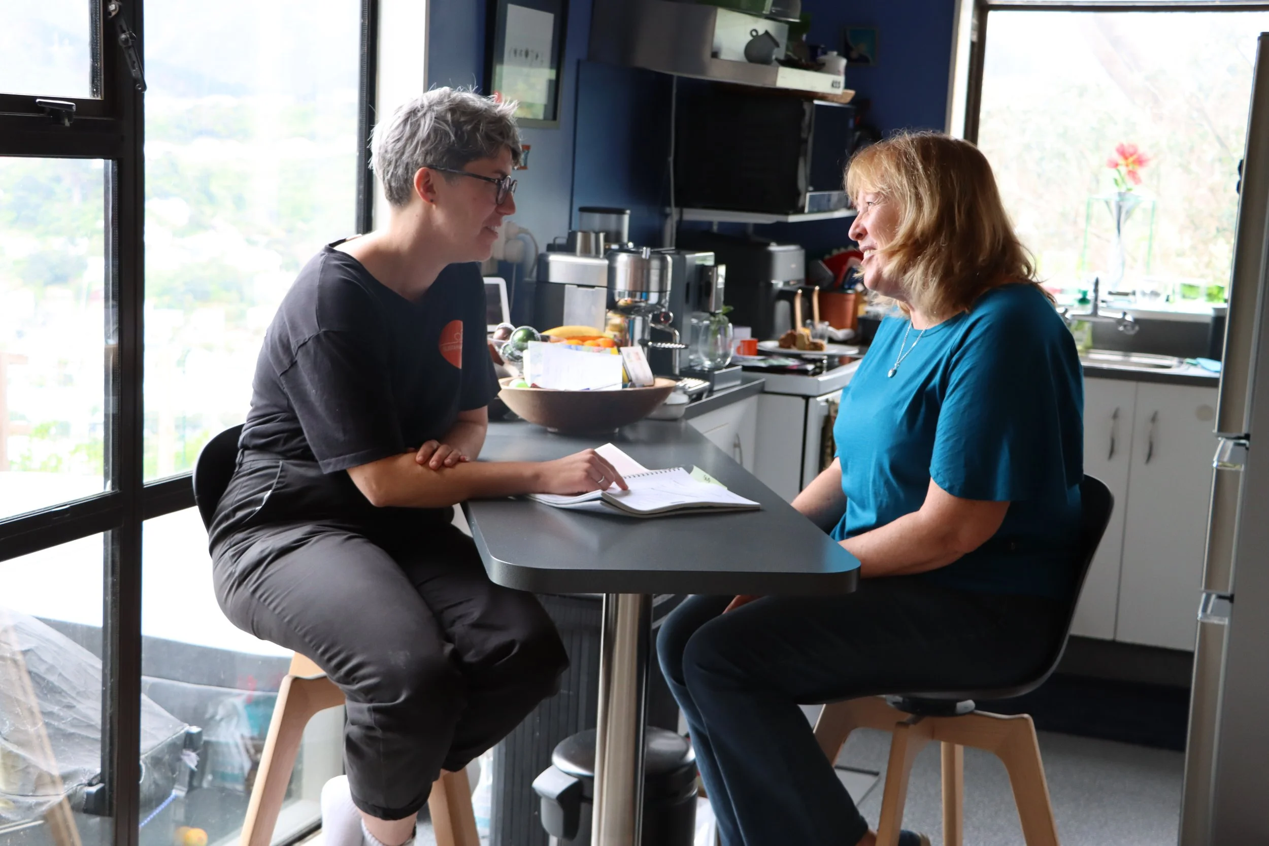 Sustainability Trust employee speaks with customer in customer's kitchen