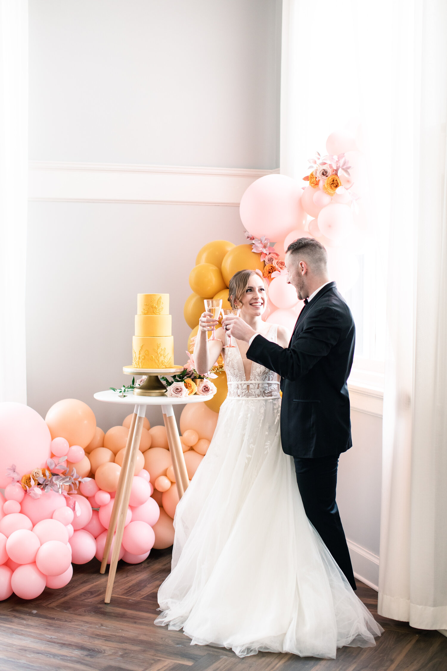 Balloon garland used to create impact behind a simple wedding cake setup. 