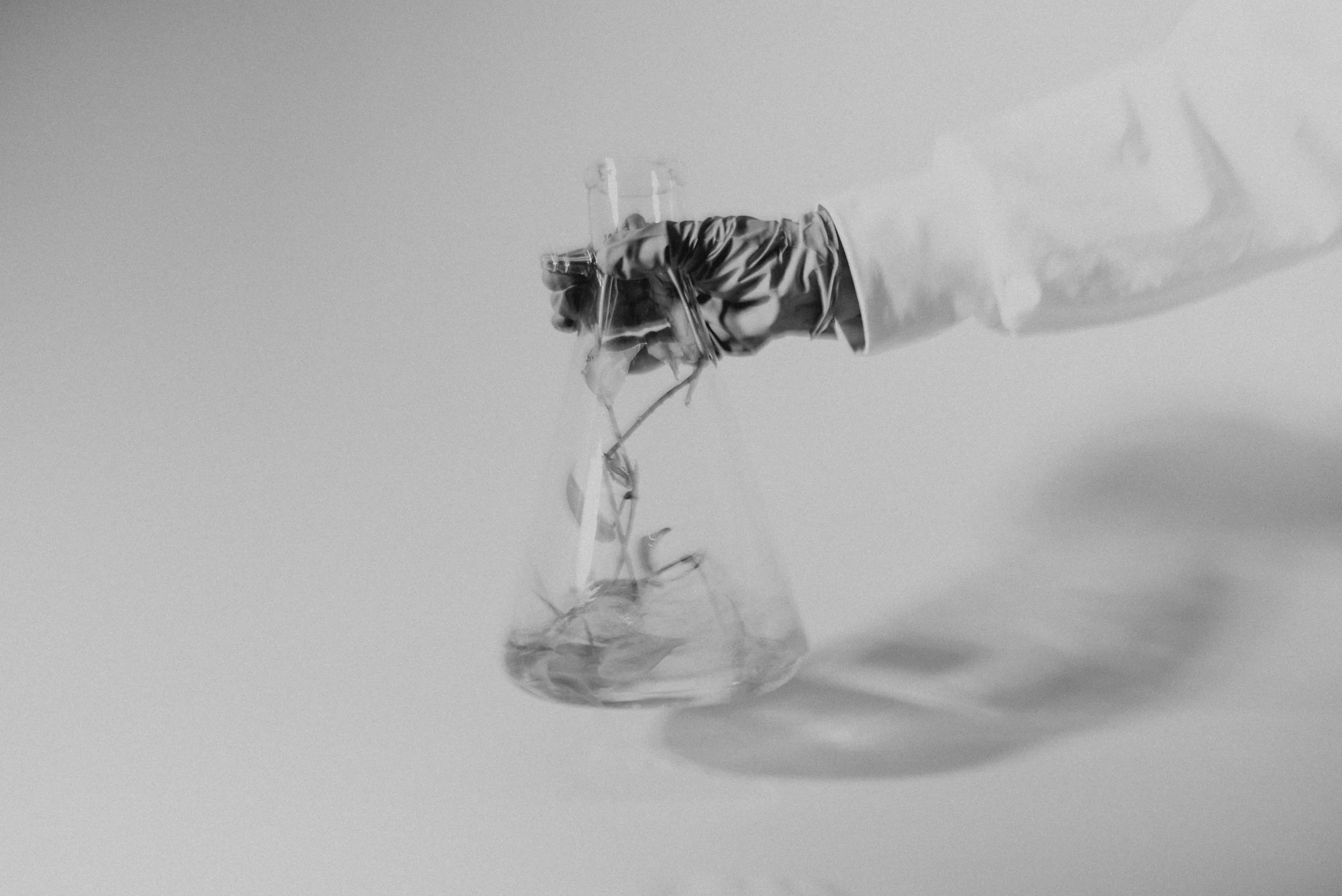 Gloved hand holding plant material above glassware during the Enveda shoot