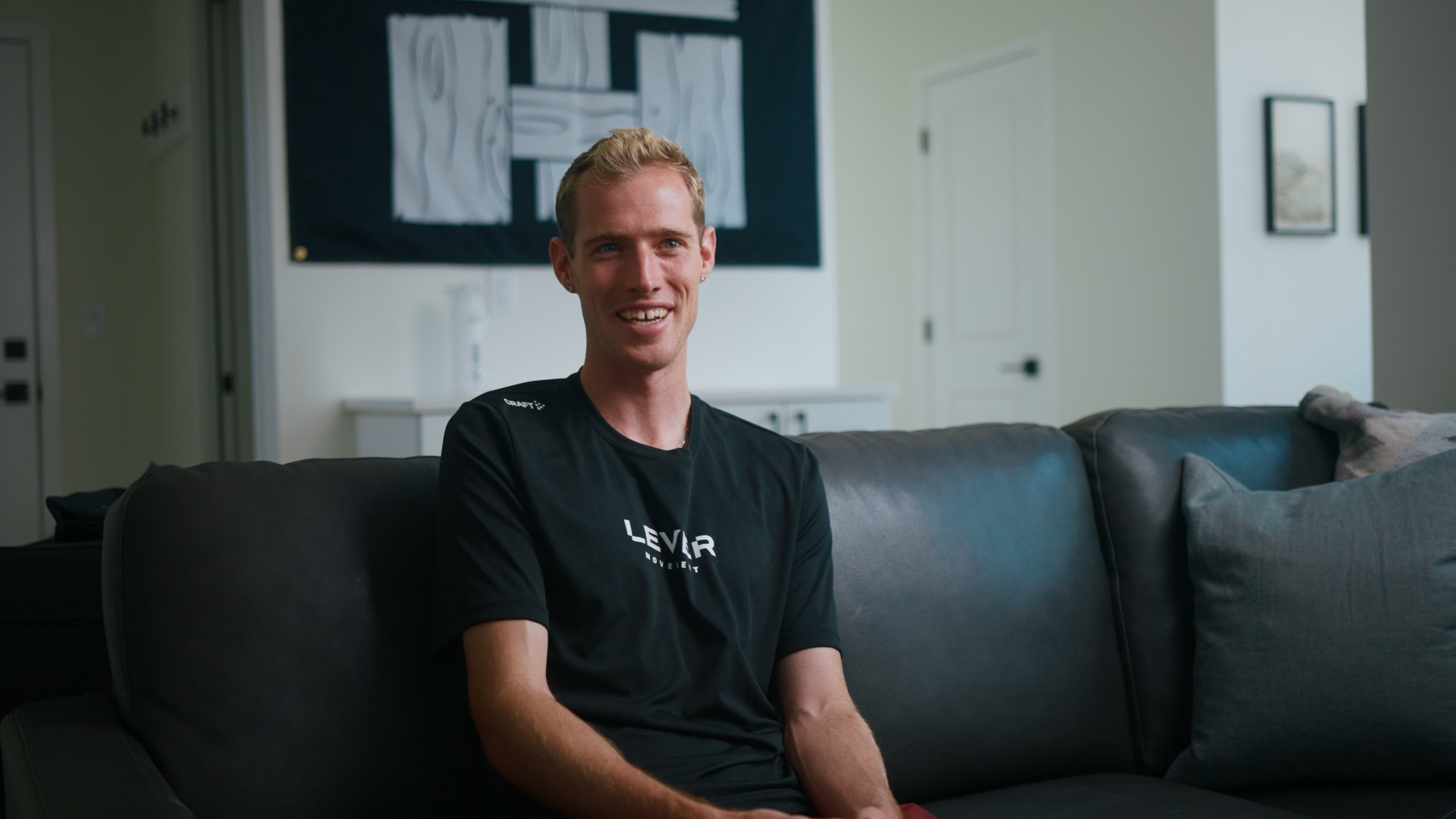 An interview with Ares Reading of the Trail House sitting on a couch in a black shirt in Boulder, Colorado