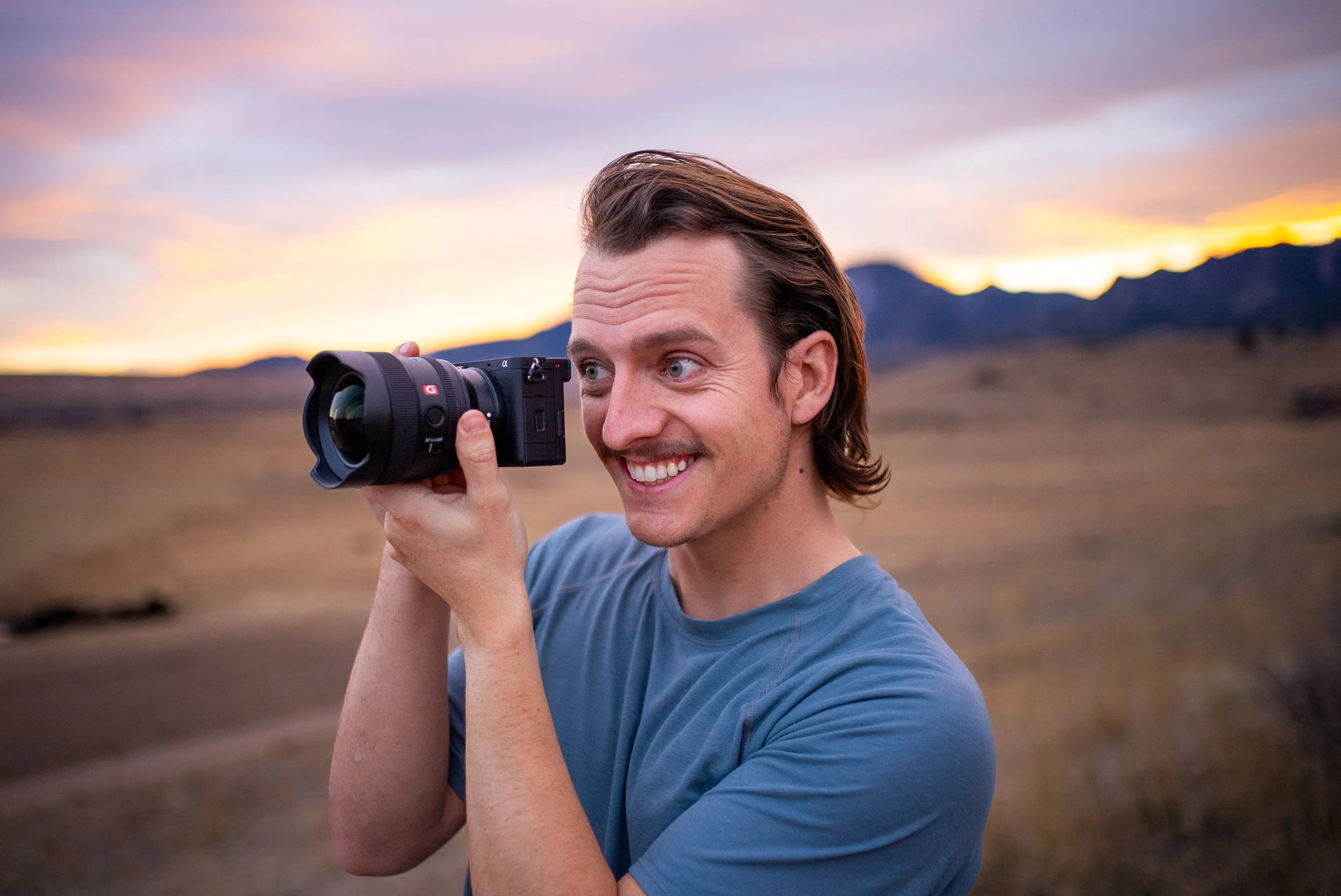 Roo Smith holding a camera and smiling