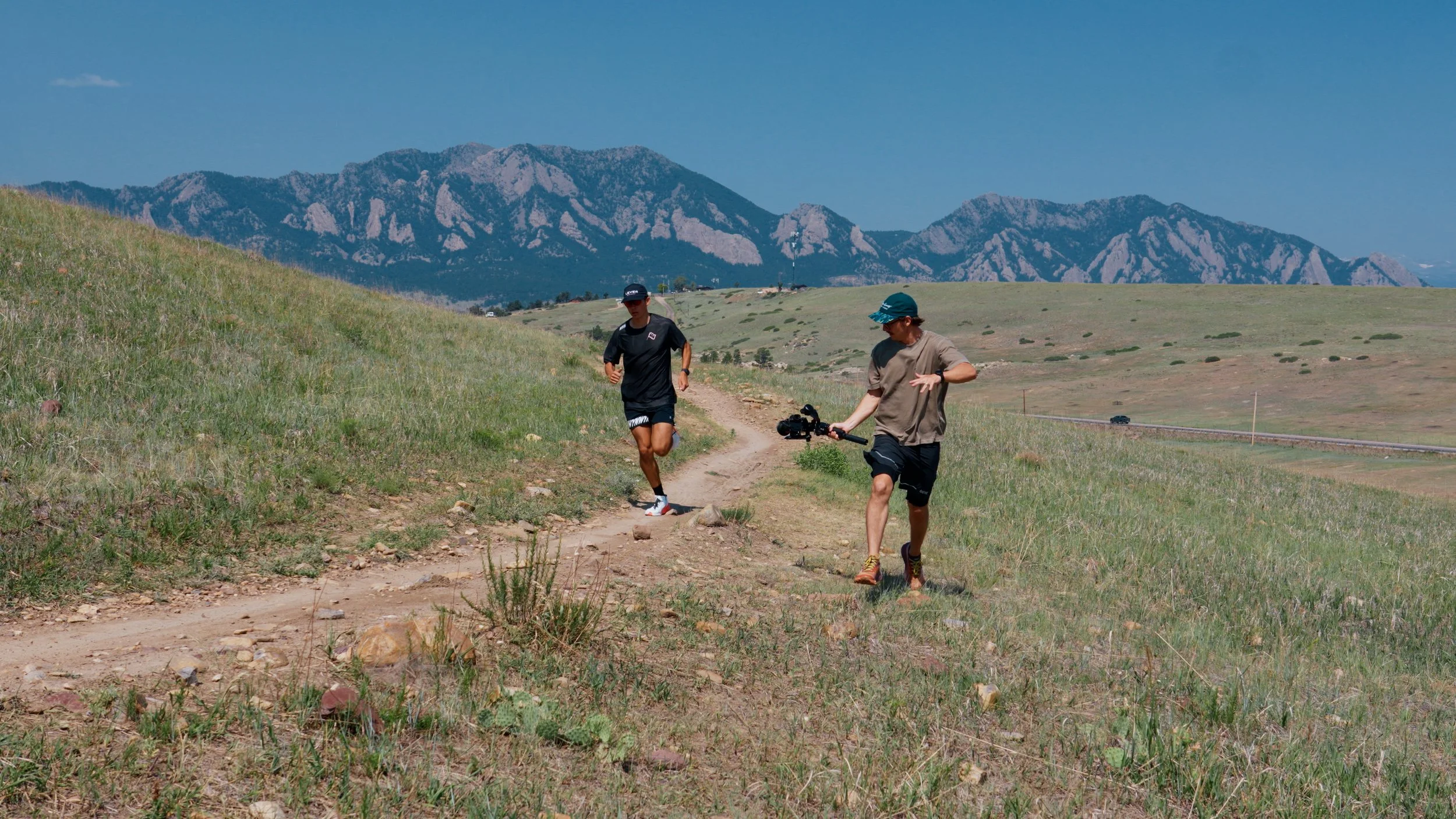 Roo Smith filming the trail house in Boulder Colorado while running next to an athlete in the foothills of Boulder, Colorado
