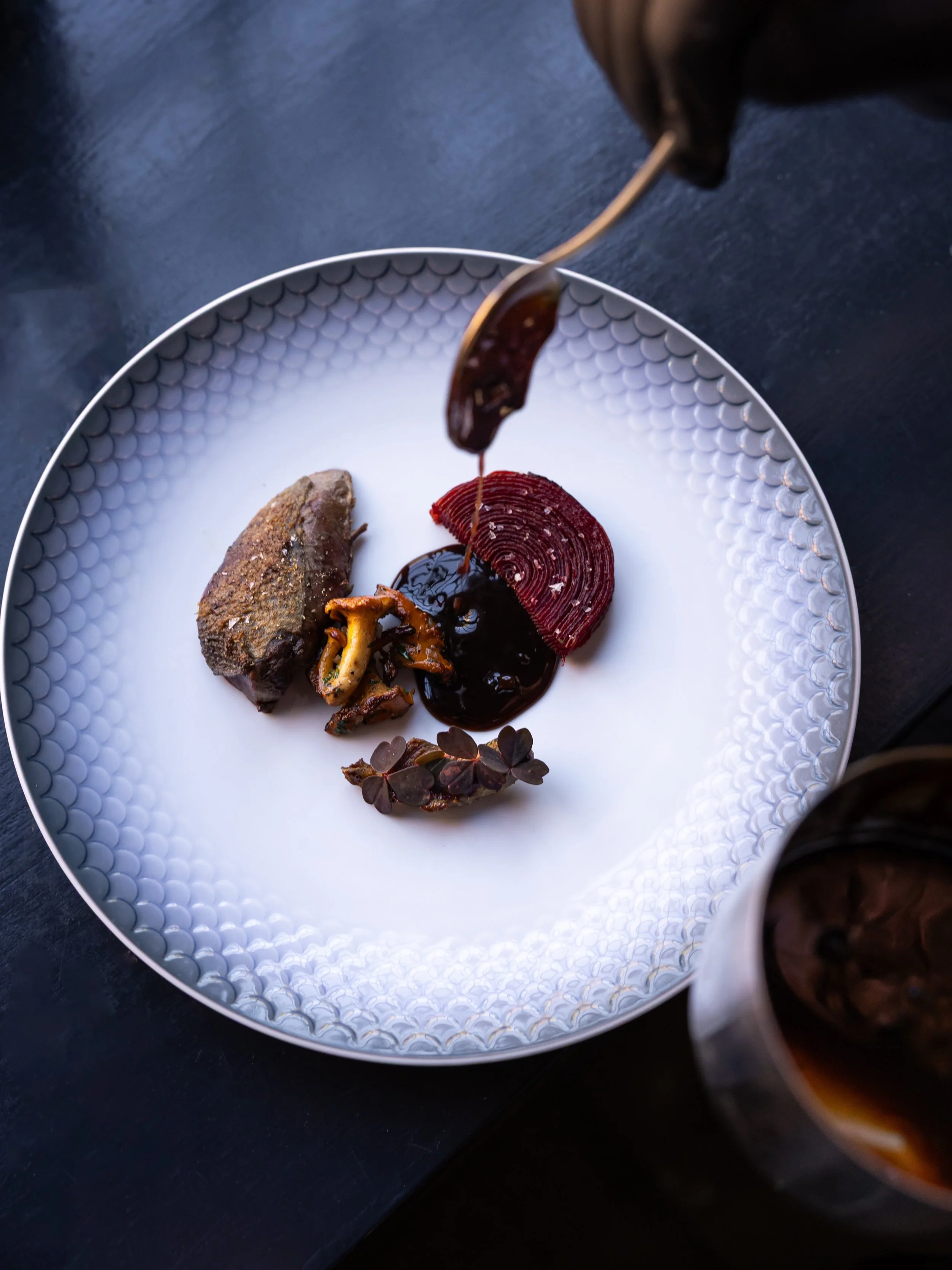 Skovdue stegt p&aring; ben med confiteret l&aring;r, kartoffel- og r&oslash;dbedefondant, stegte kantareller og tr&oslash;ffelsauce. En ret med masser af smag, der kalder p&aring; et godt glas vin og en hyggelig aften i Nikolaj Kirkes historiske ramm
