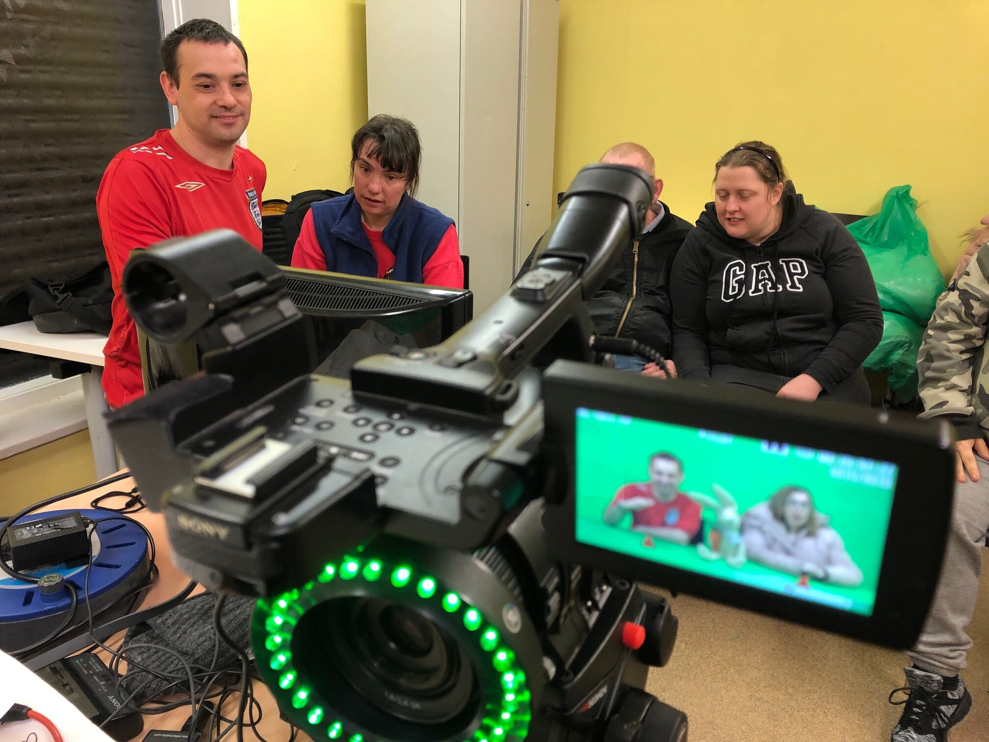 Group of participants using the green screen to film a scene