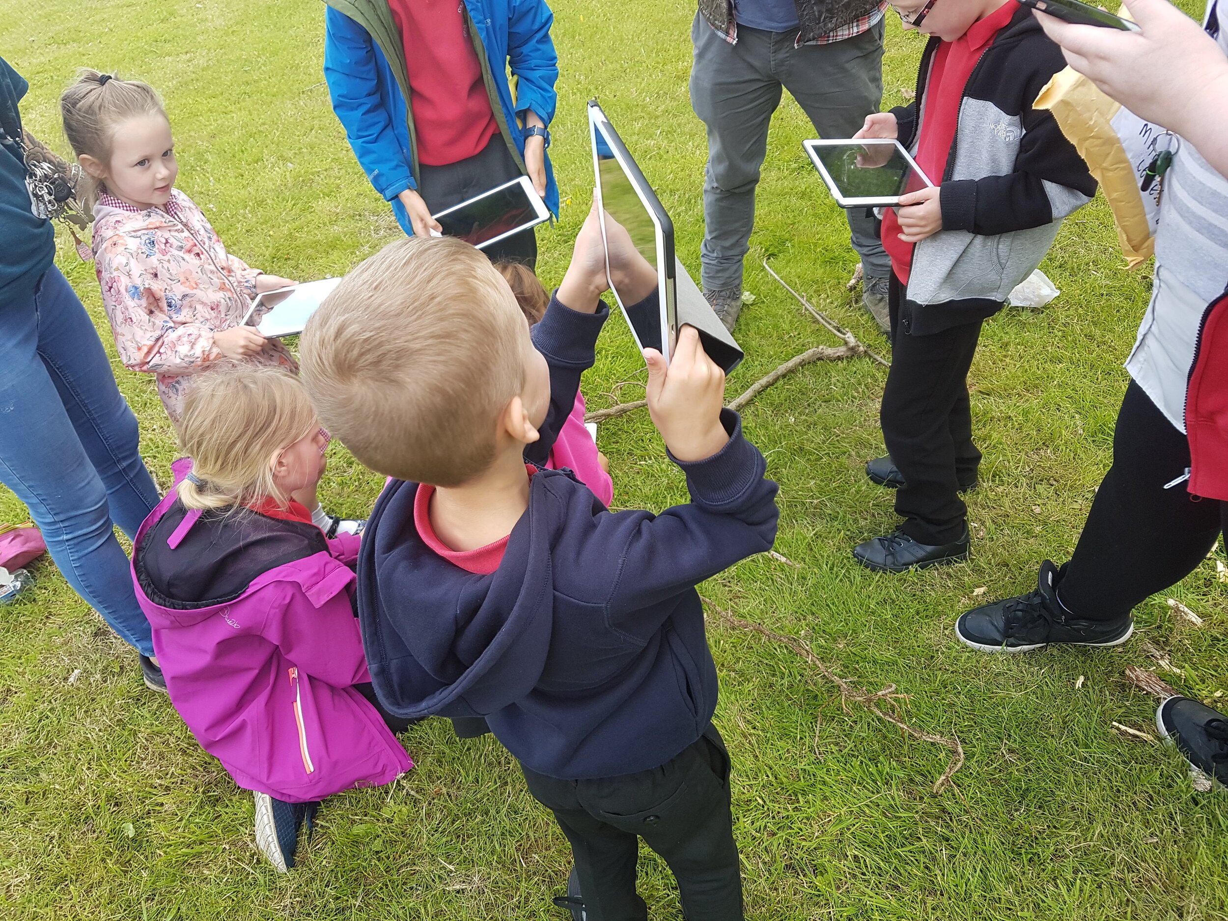 Group of school children learning how to take pictures on the ipad