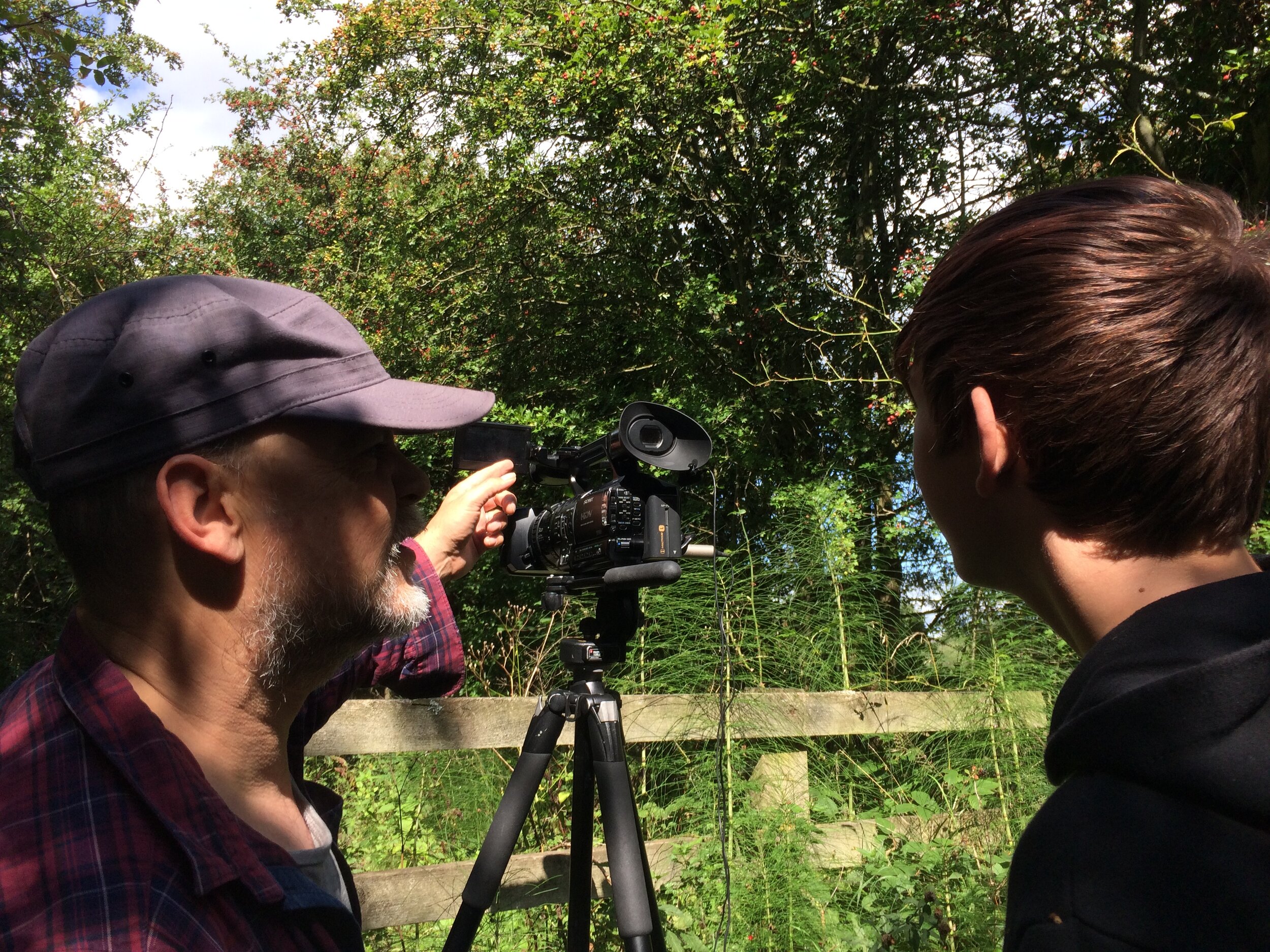 Person showing a young boy how to use the camera