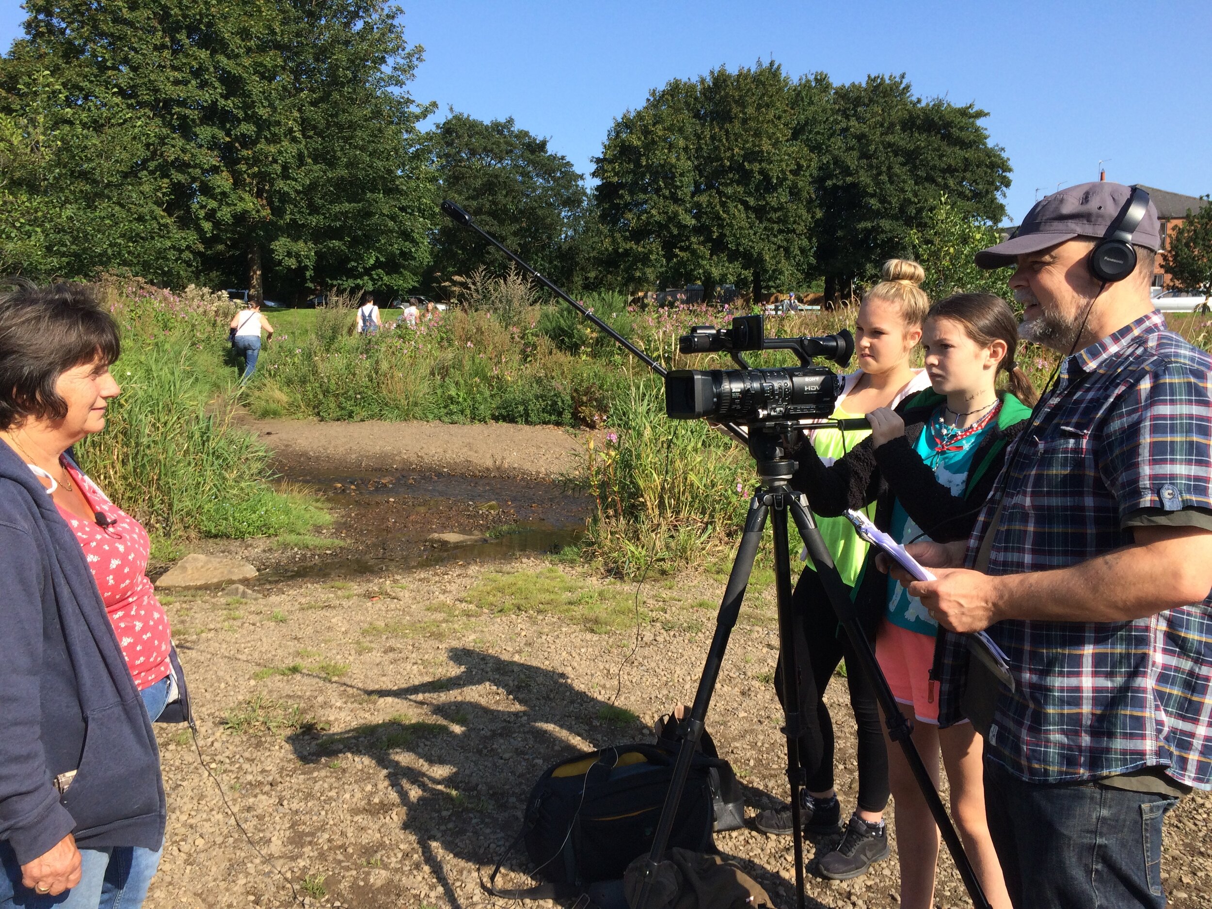 Tutor showing a group of people how to film an interview 