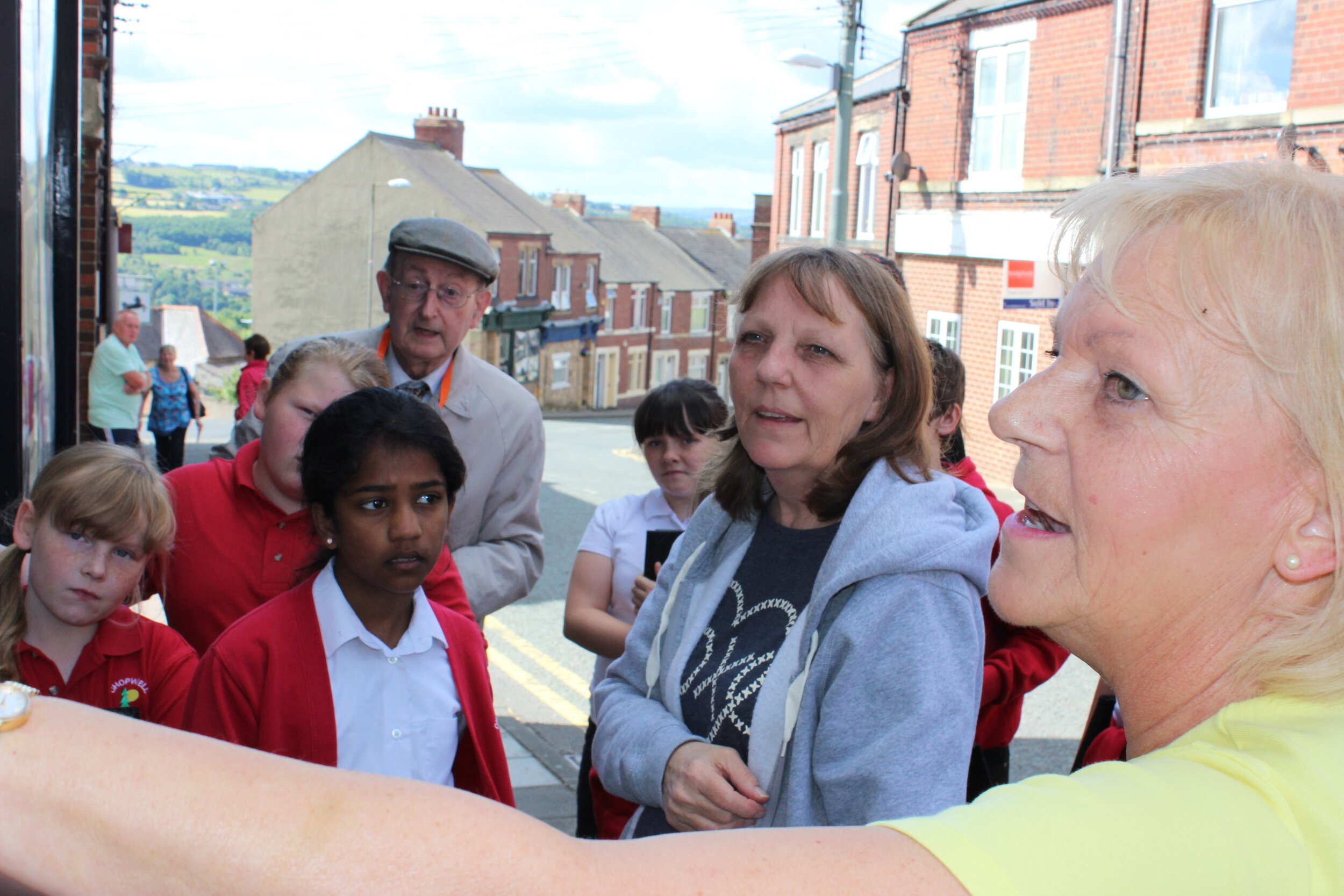 Group of school children being taught about the history of their village