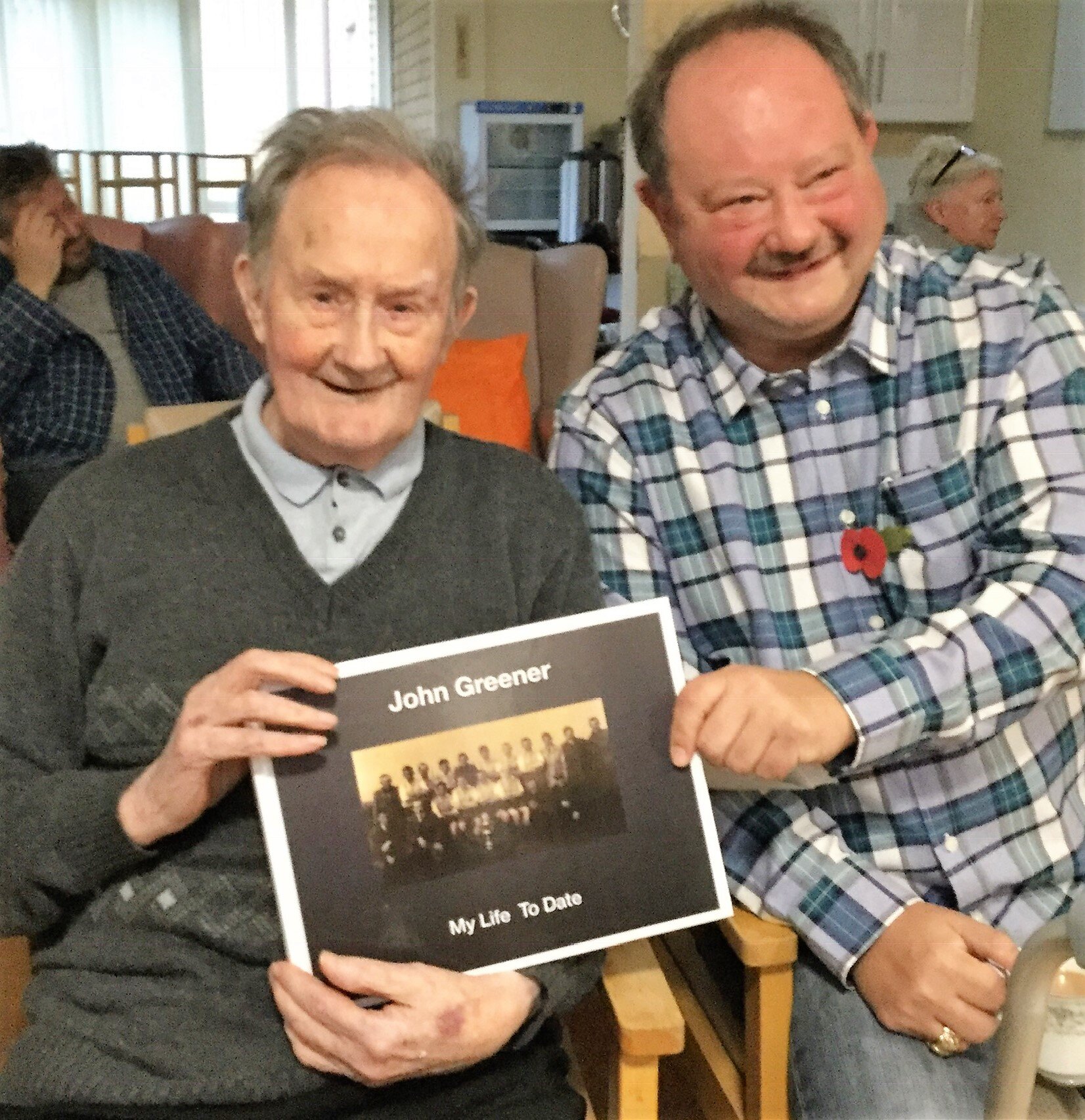 Two men showing off their finished printed version of the lifebook