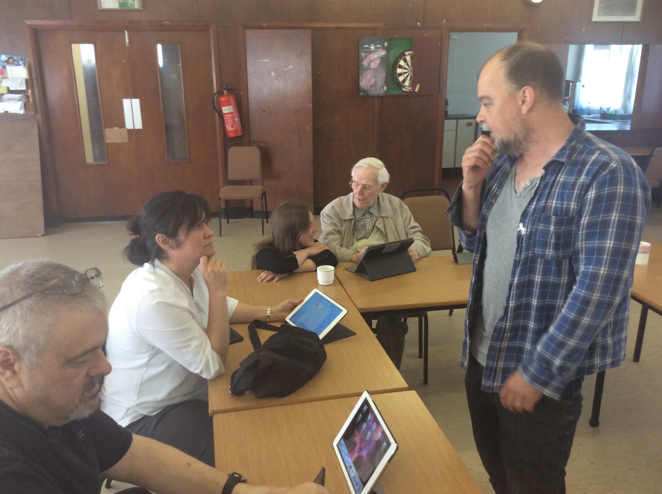 Tutor teaching a group how to use the ipads