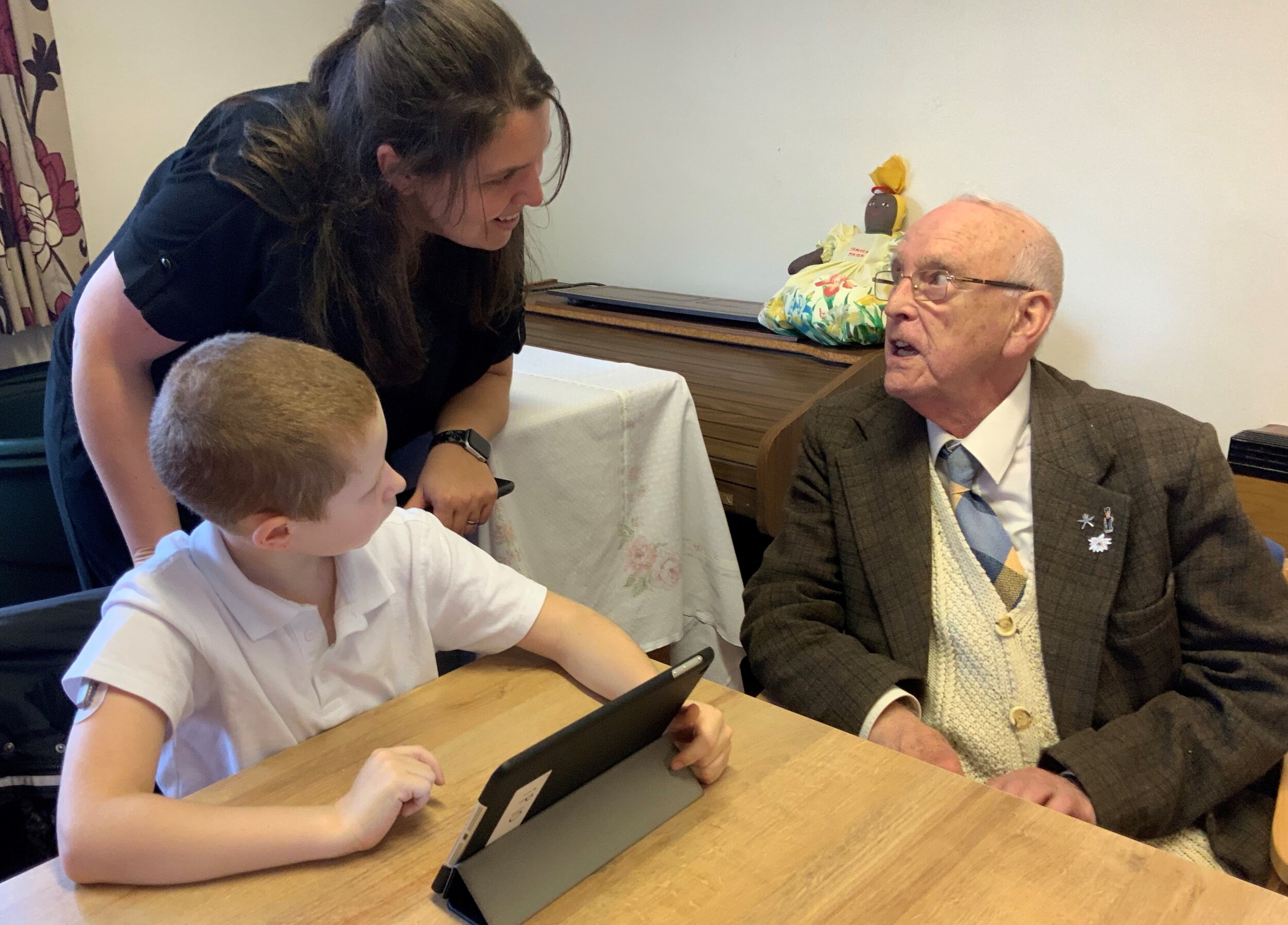 Tutor explaining how some features work to a school boy and older man