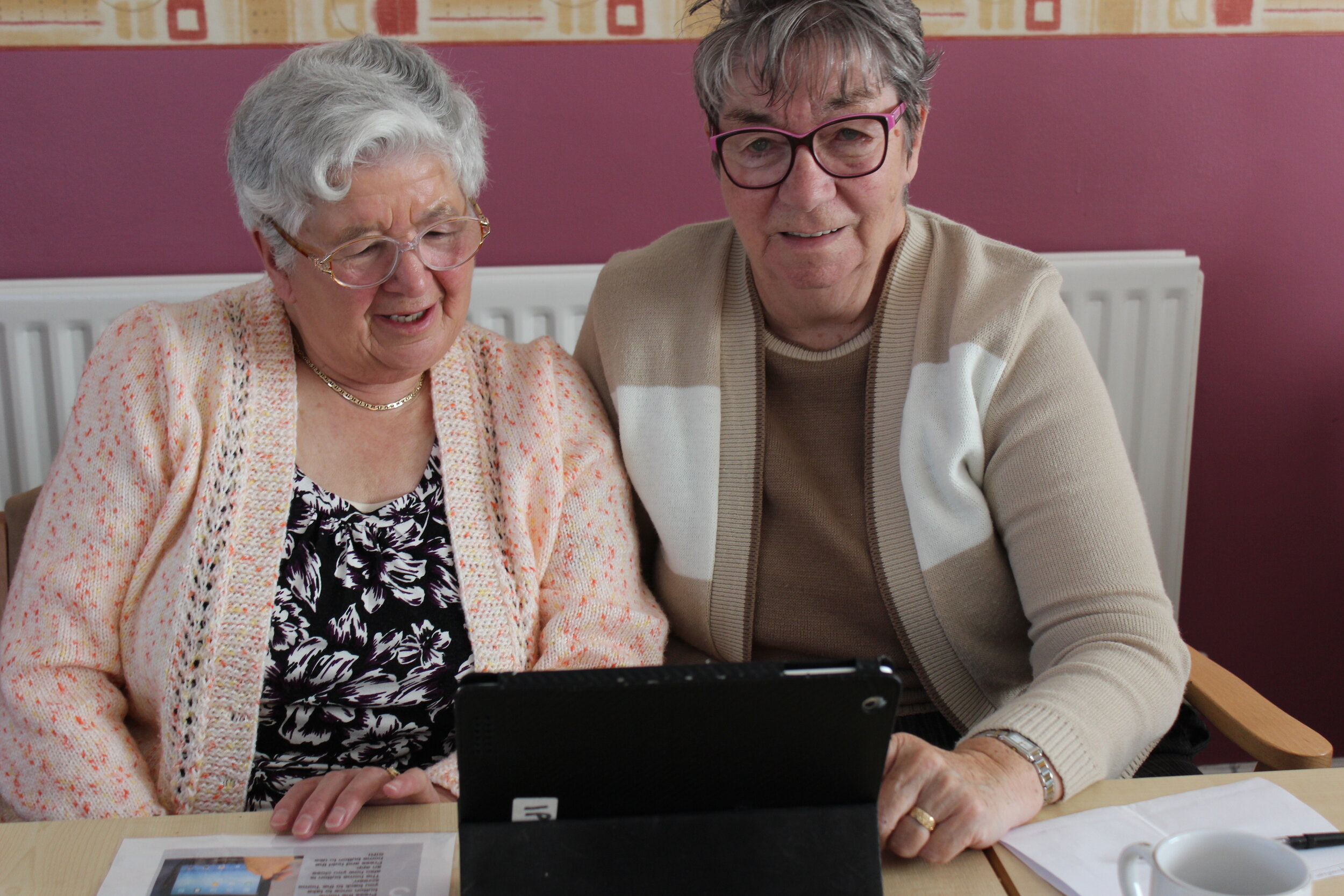 Two older people learning to use ipads