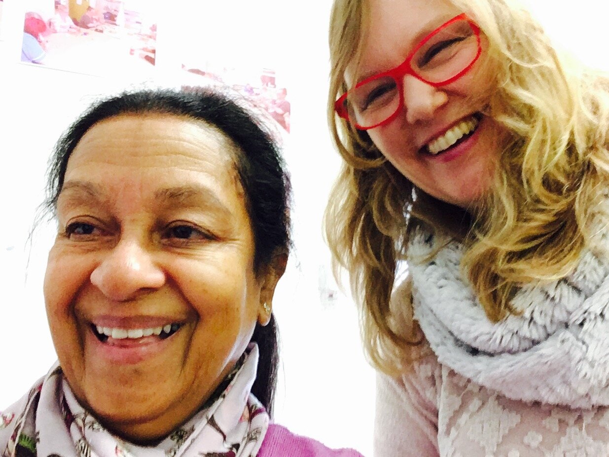 two ladies smiling in a selfie they have taken on the ipads