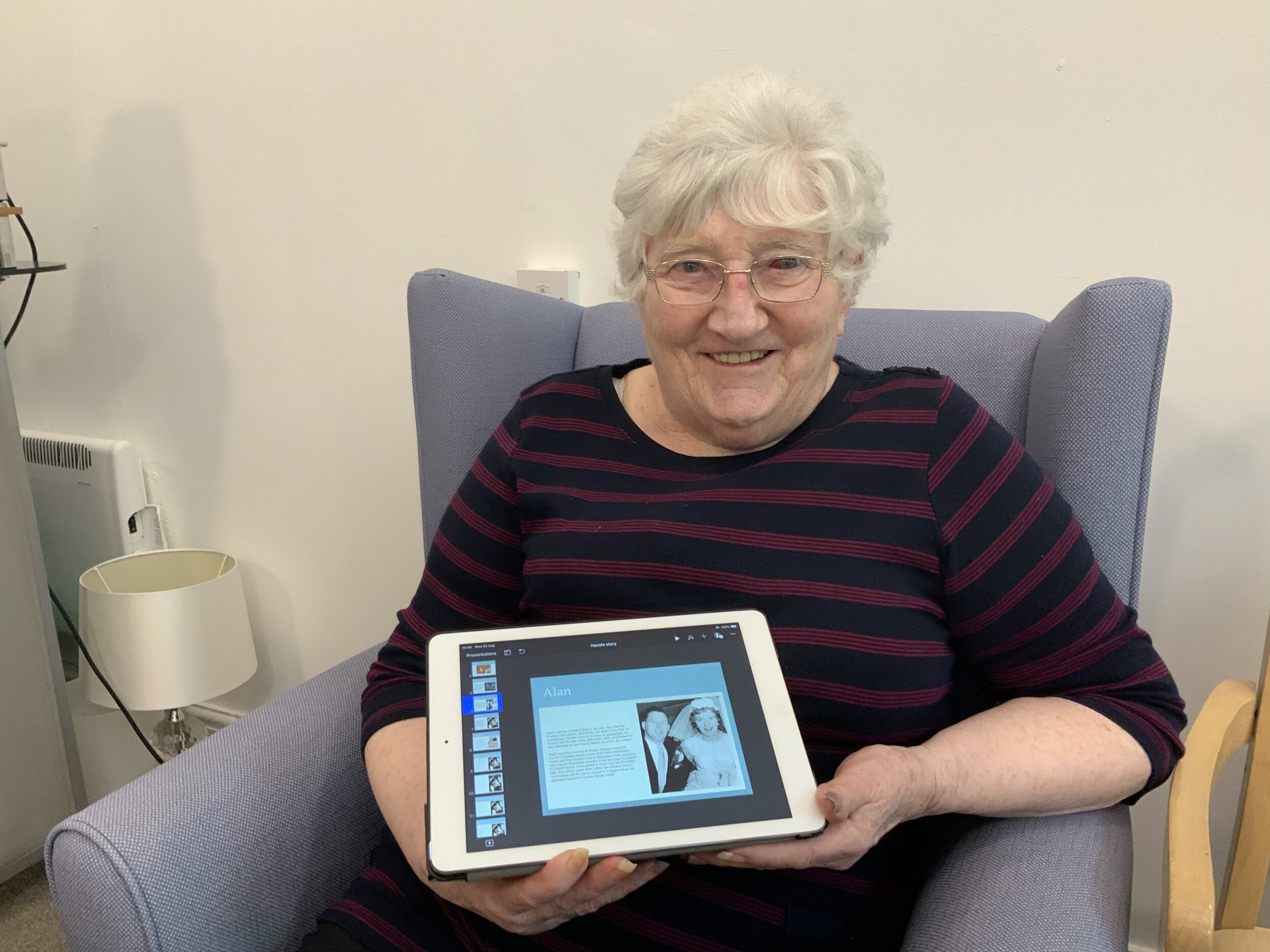 Care home resident holding an ipad with her lifebook on the screen