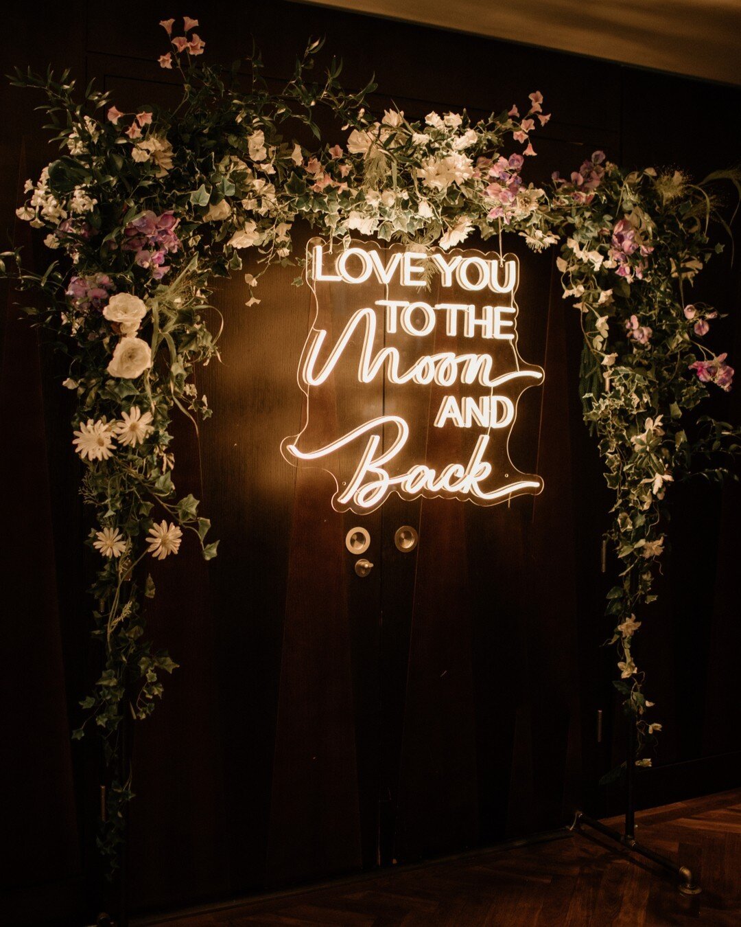 Backdrops don't always have to be massive to have impact - this was a wild and floral installation for Abbie &amp; Brody's wedding with our cute neon sign ready for first dance time!