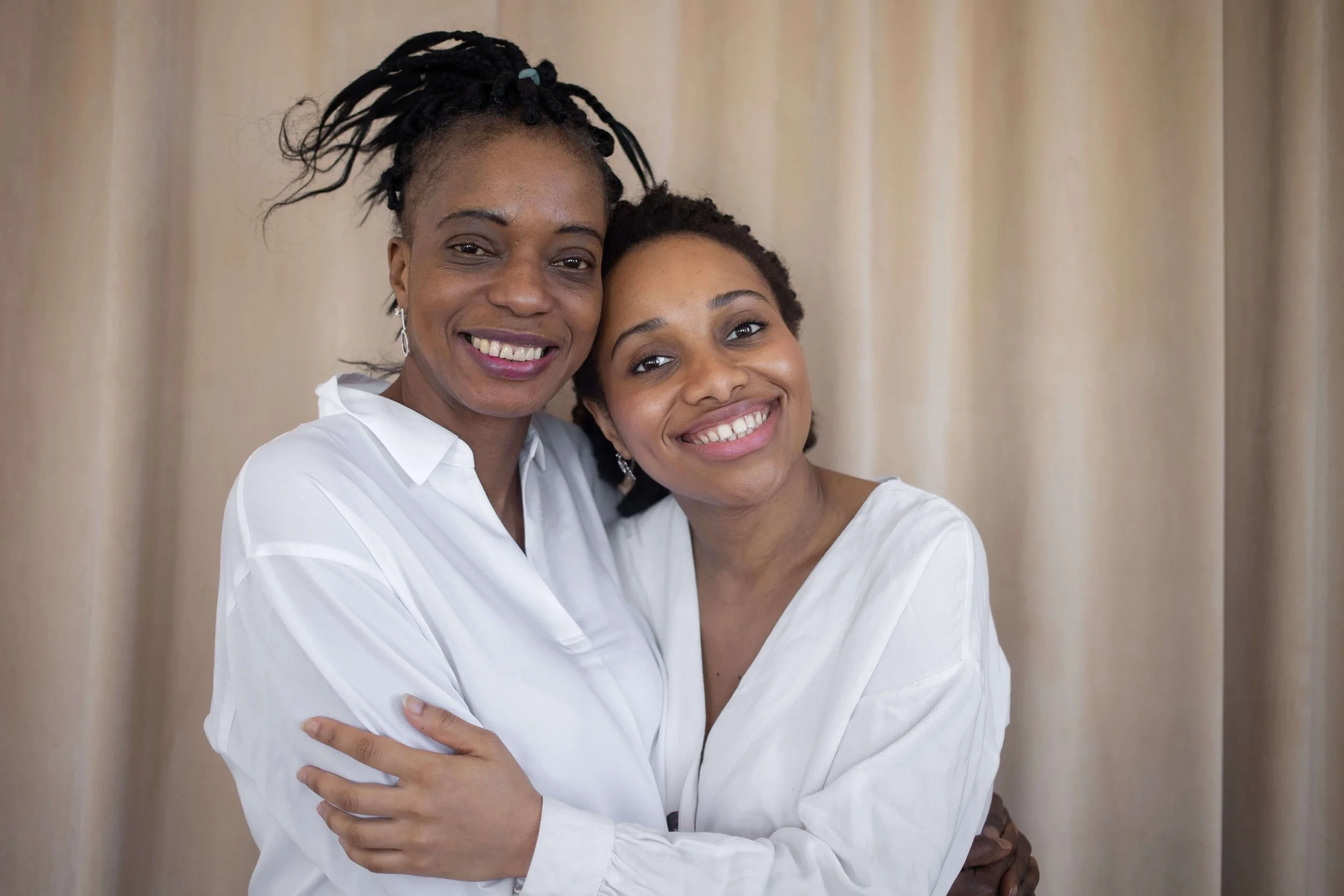 mother and daughter hugging and smiling at camera