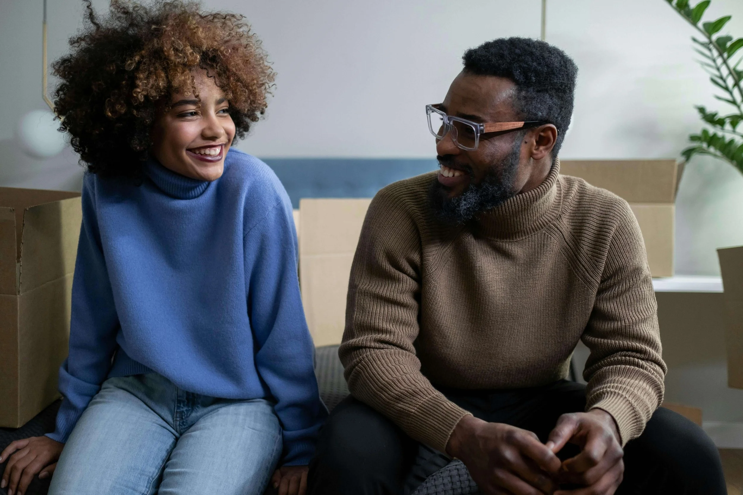 Man and woman sitting down and smiling at eachother