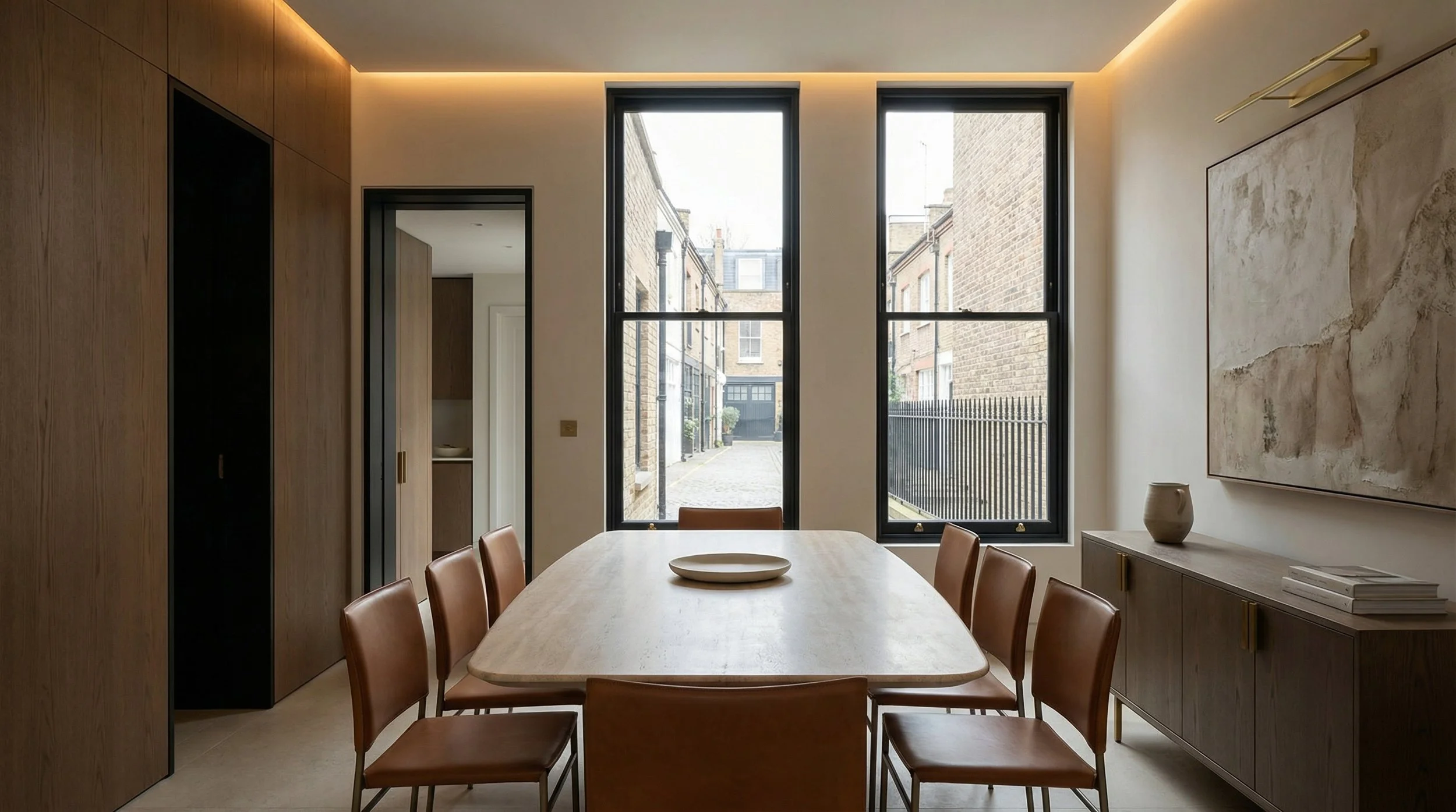 Luxury minimalist dining room in London featuring bespoke oak panelling, leather dining chairs, and soft cove lighting, designed by Harun Taylor Design