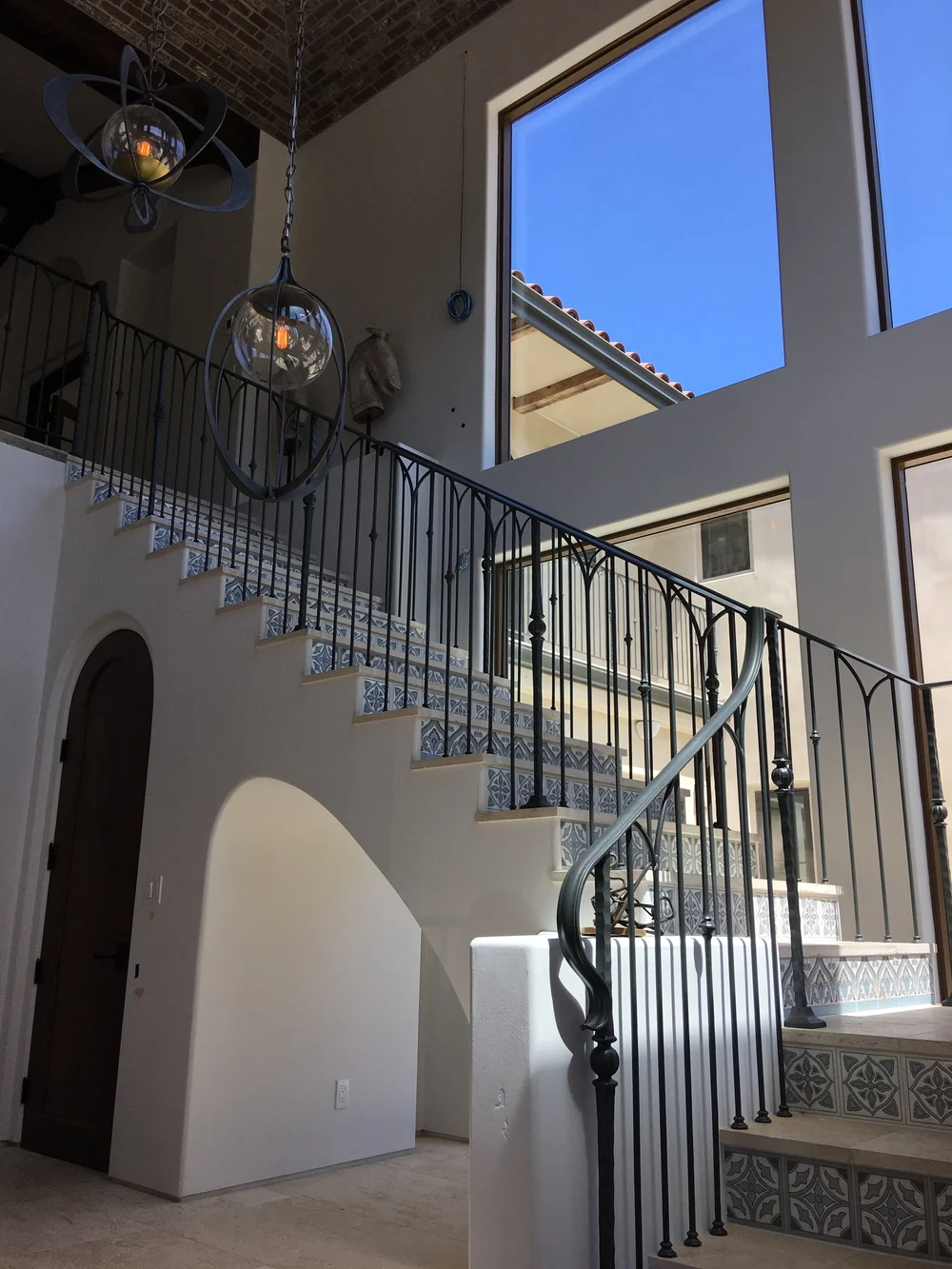  In the entryway, guest are greeted by a beautiful set of stairs leading up to the second story that are adorned with hand-painted recycled clay tile. A flood of natural light bathes the entry, courtesy of floor-to-ceiling windows. 