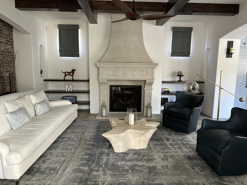  The living room features beamed ceilings, more brick to mirror the ceiling in the entry, and boasts a beautiful cast stone fireplace with custom detailing right off the kitchen.&nbsp; 
