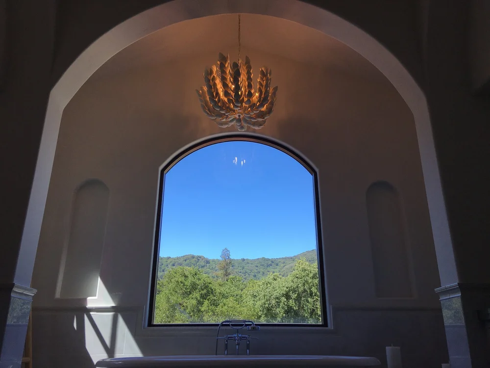  The view outside is perfectly framed in the primary bath arched window. 