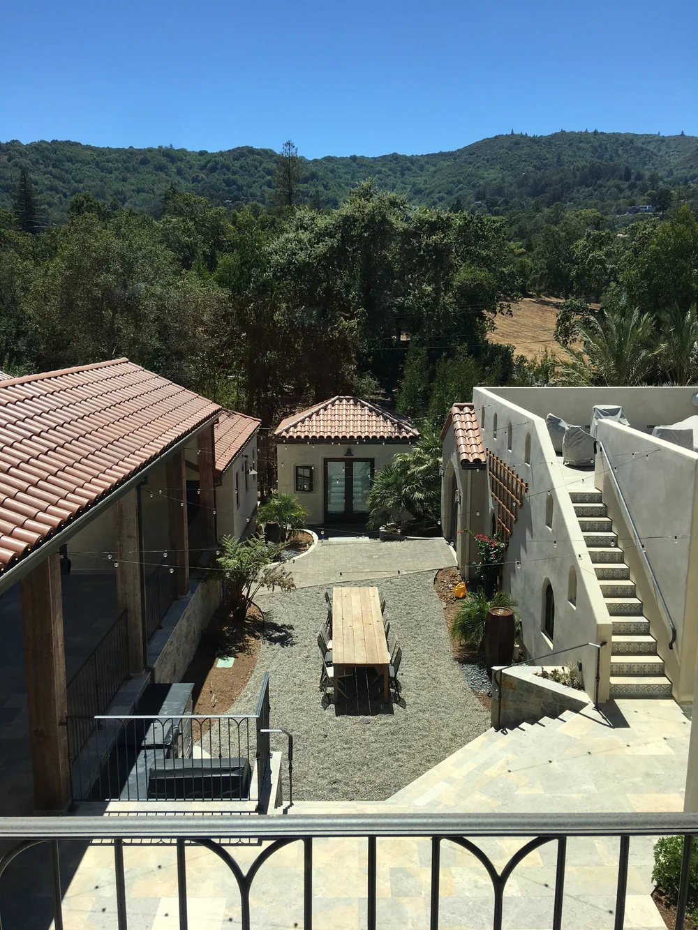  The second story balcony showcases a view of the courtyard below and the hills beyond. 