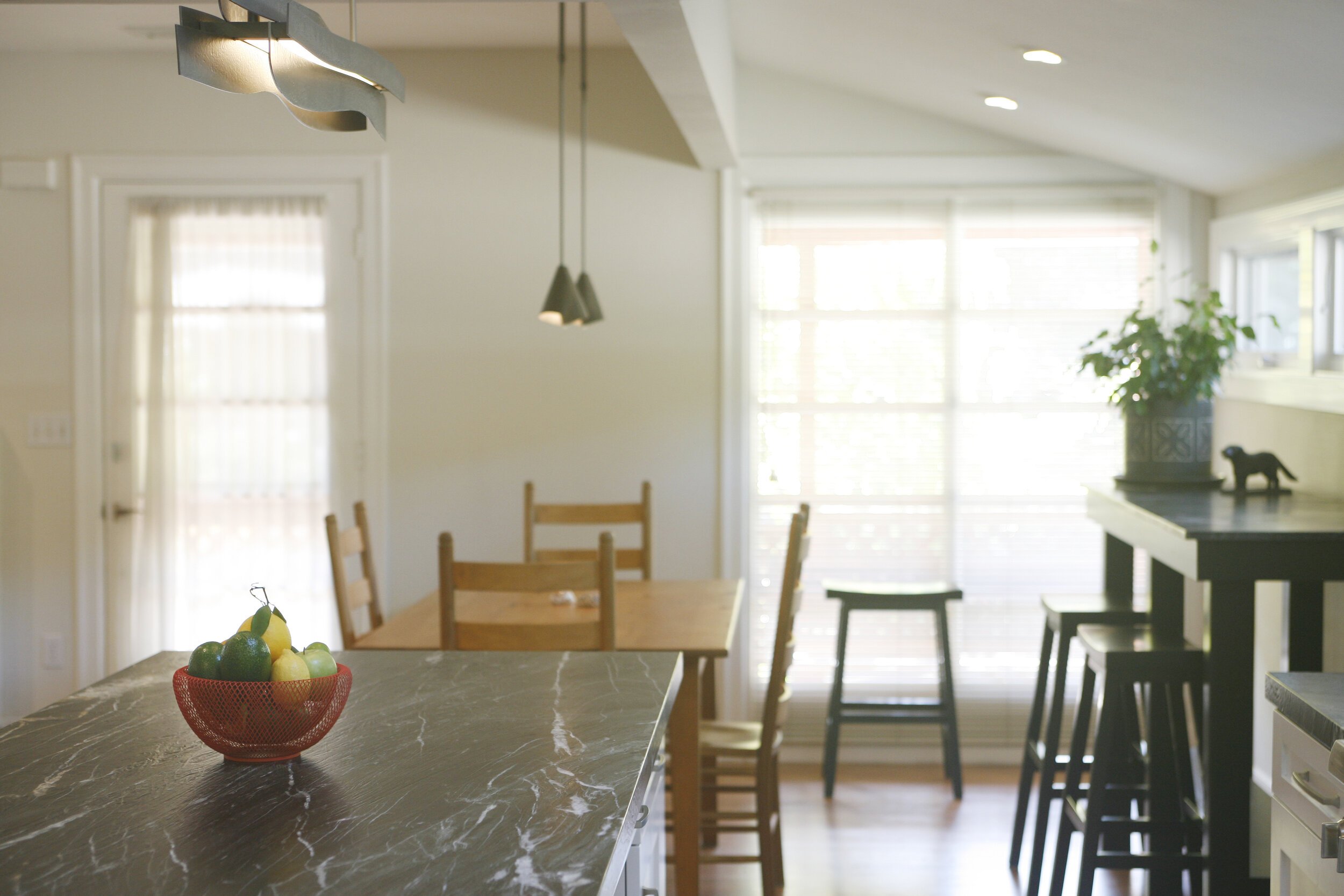 By reworking the original kitchen and entry areas, we were able to create a sizable dining area for Joanne, complete with a table and chairs and separate bar seating area for an up-close view of the mountains beyond.