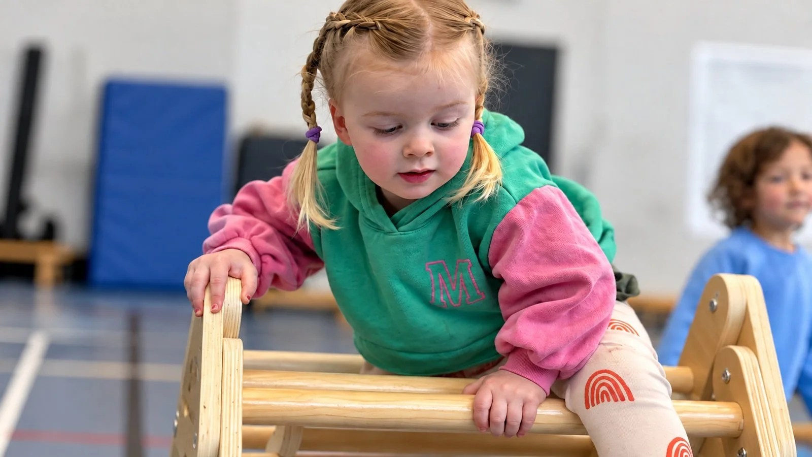 A young child exploring the gymnastics apparatus; an edited GymLab photograph.
