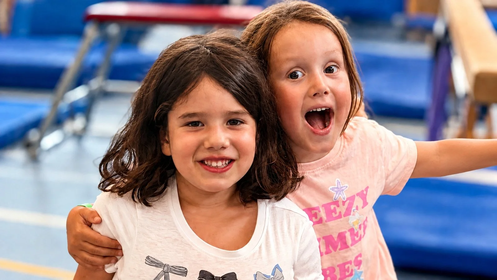 Two children sharing a smile in the gym; an edited GymLab photograph.