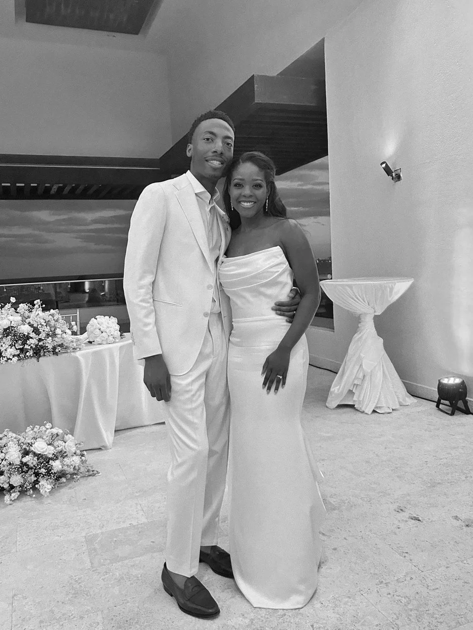Black and white portrait of a bride and groom posing together indoors