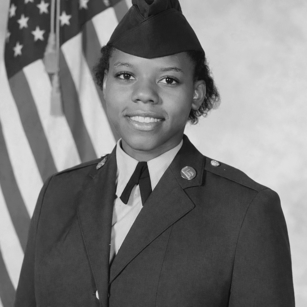 Black and white portrait of LaTonya Speights in U.S. military uniform standing in front of an American flag