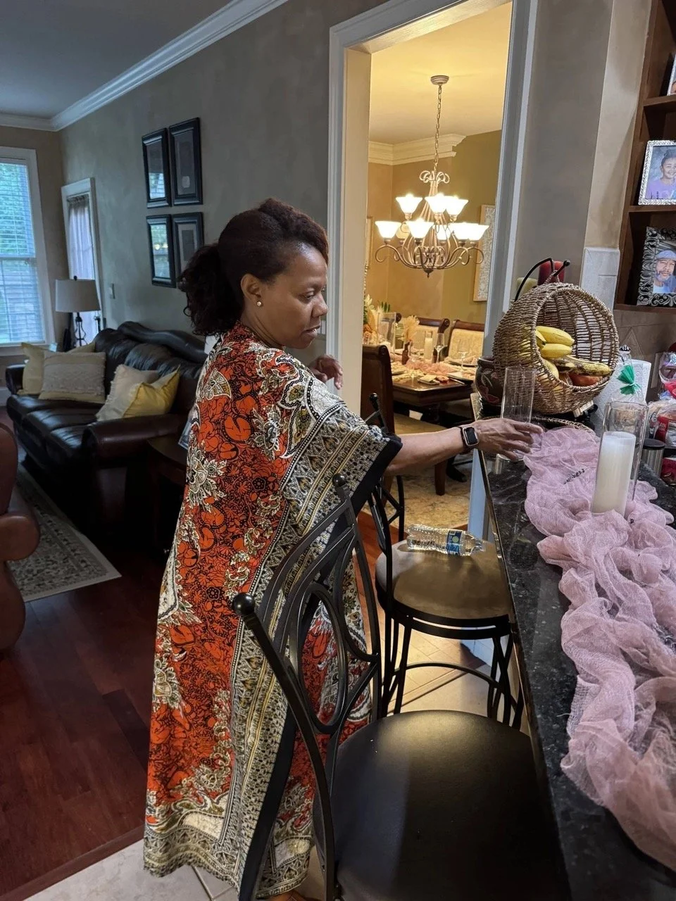 Latonya, owner of Booked Elegant Events arranging glassware and decor during behind-the-scenes setup for a social event