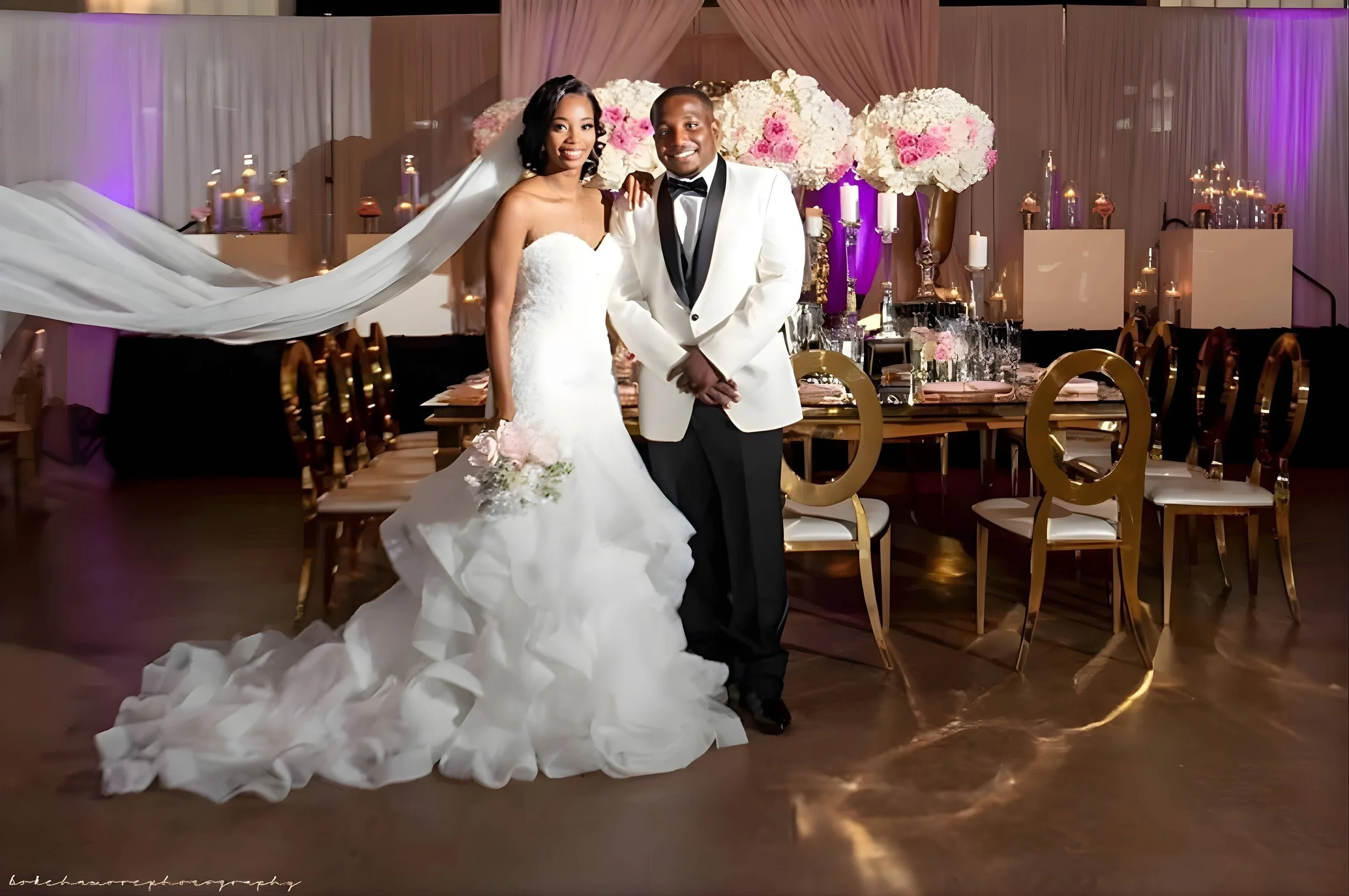 Bride and groom standing together in front of an elegant wedding reception setup