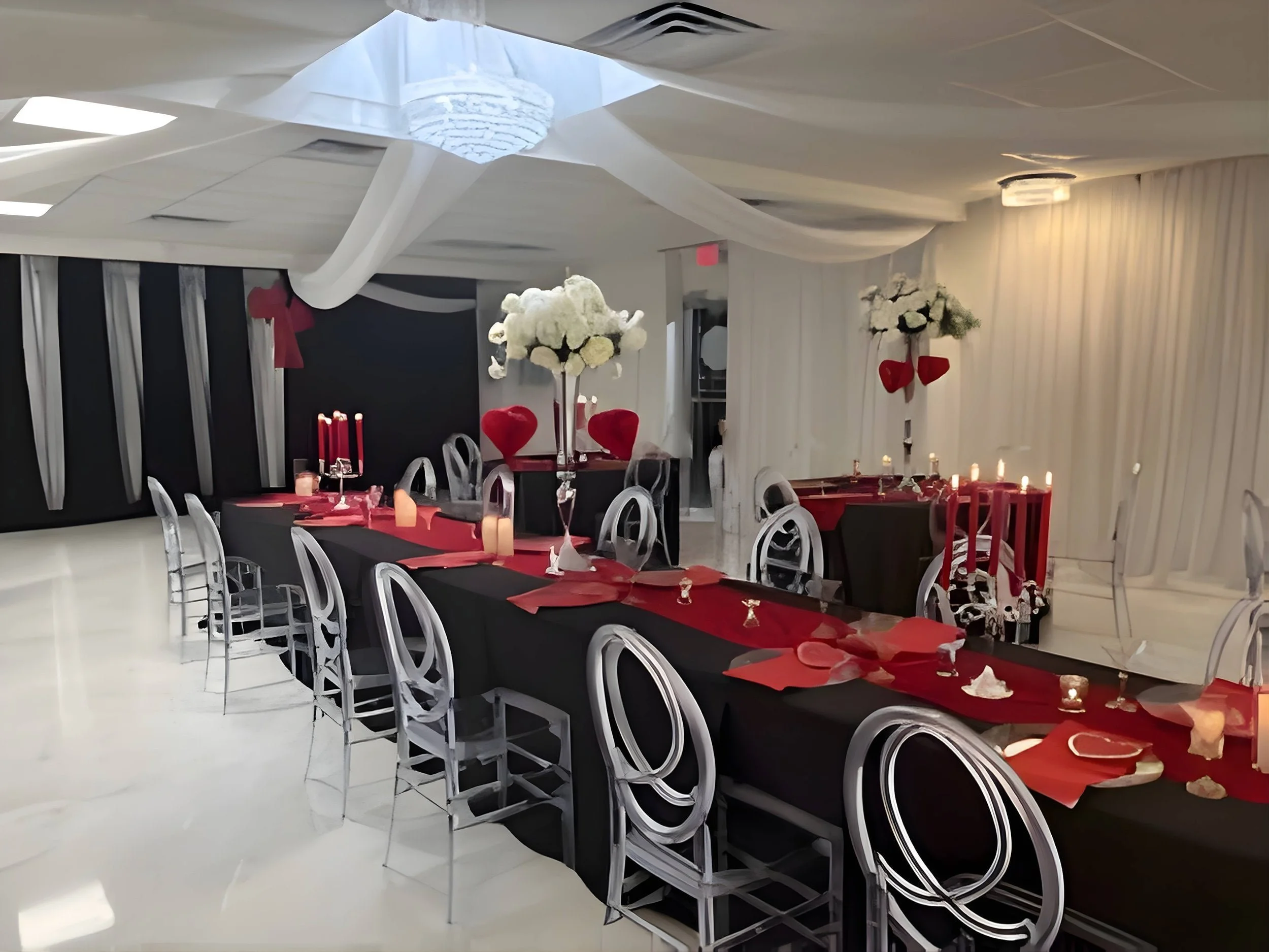 

Long social event table with red runner, candles, clear chairs, and modern table styling
