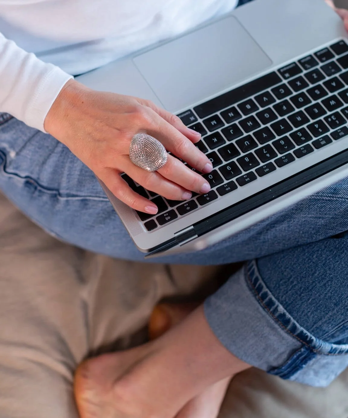 Jo Lofthouse, integrative psychotherapist and therapist coach's hands on a laptop keyboard