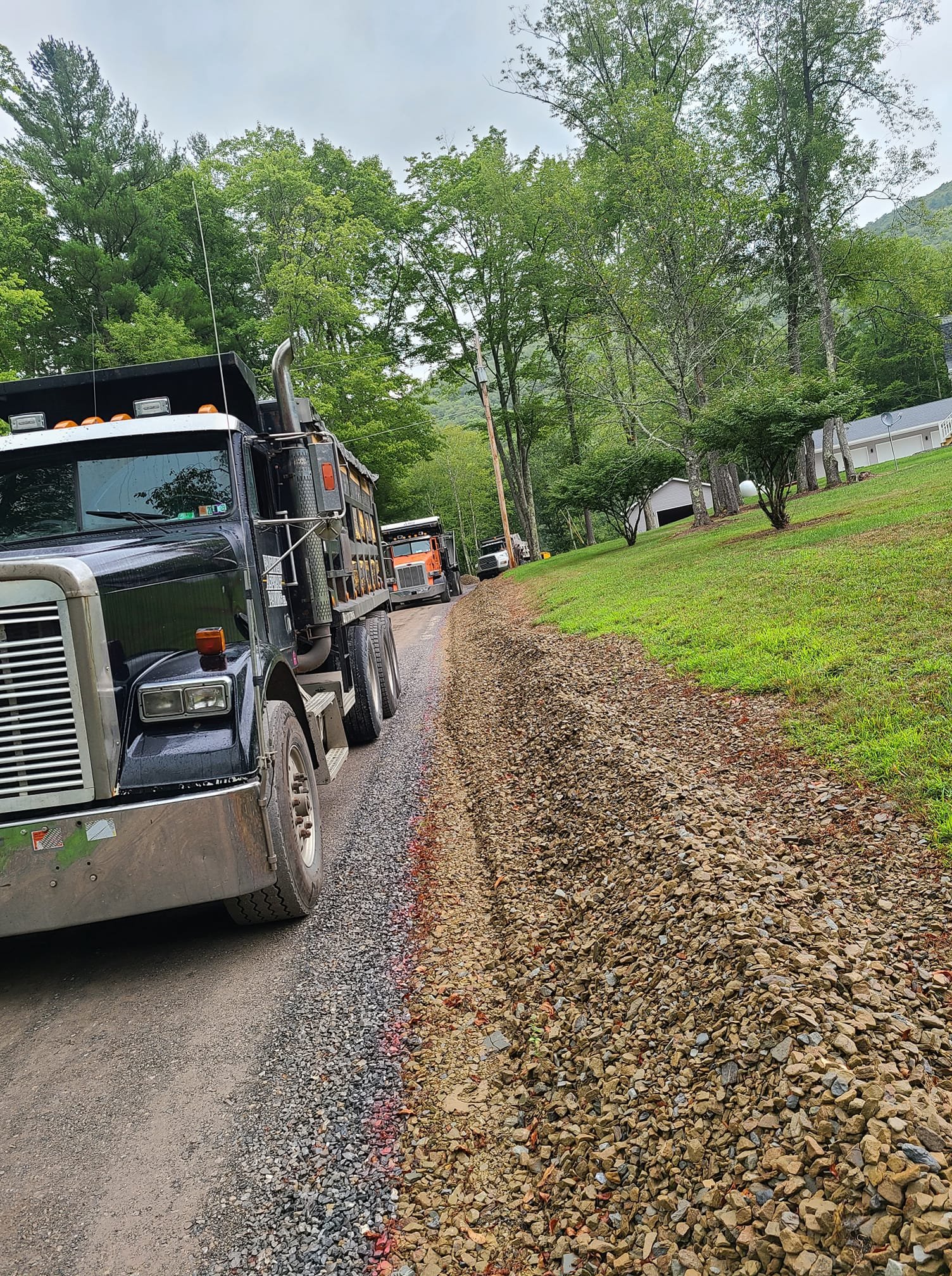 Lining up the Fairview Asphalt Paving trucks for a long residential driveway