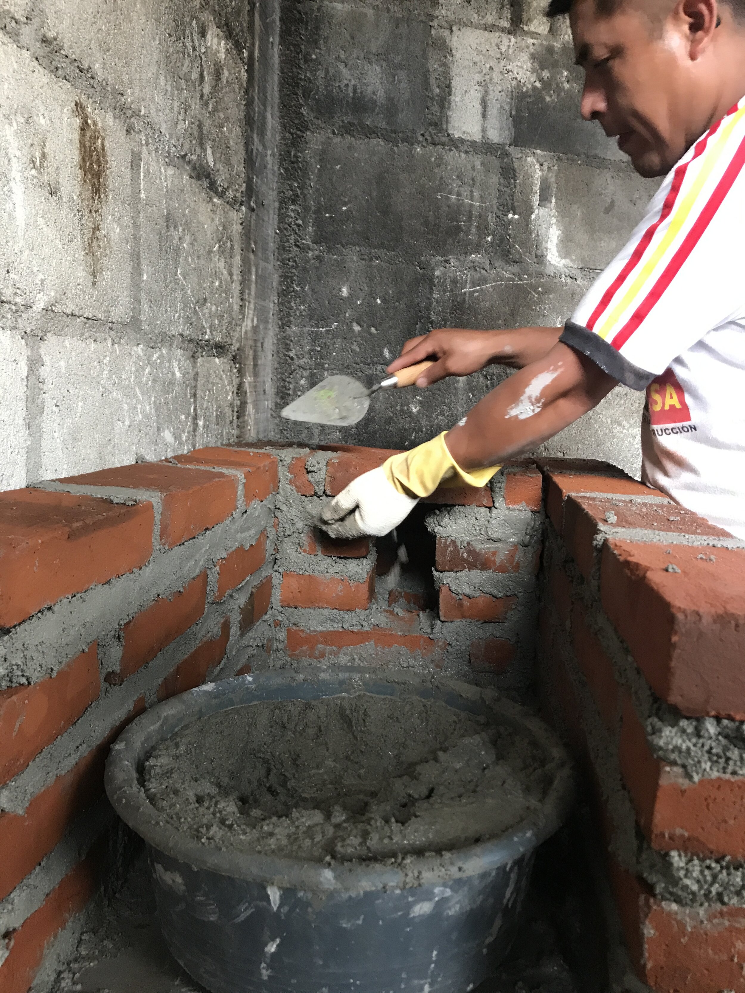 Step 2: The technician lays bricks to form the walls.